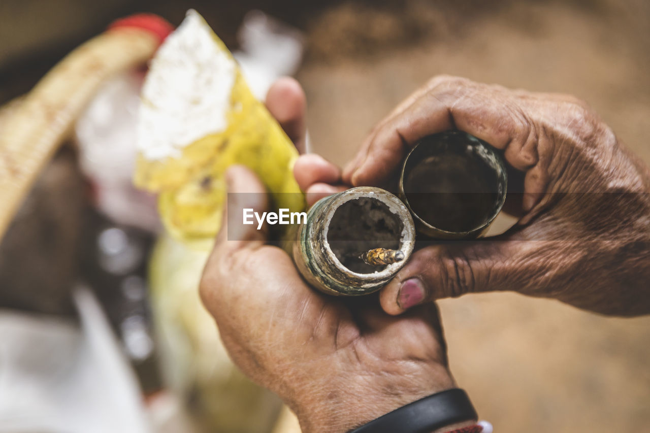 Cropped image of hands holding dirty bottles