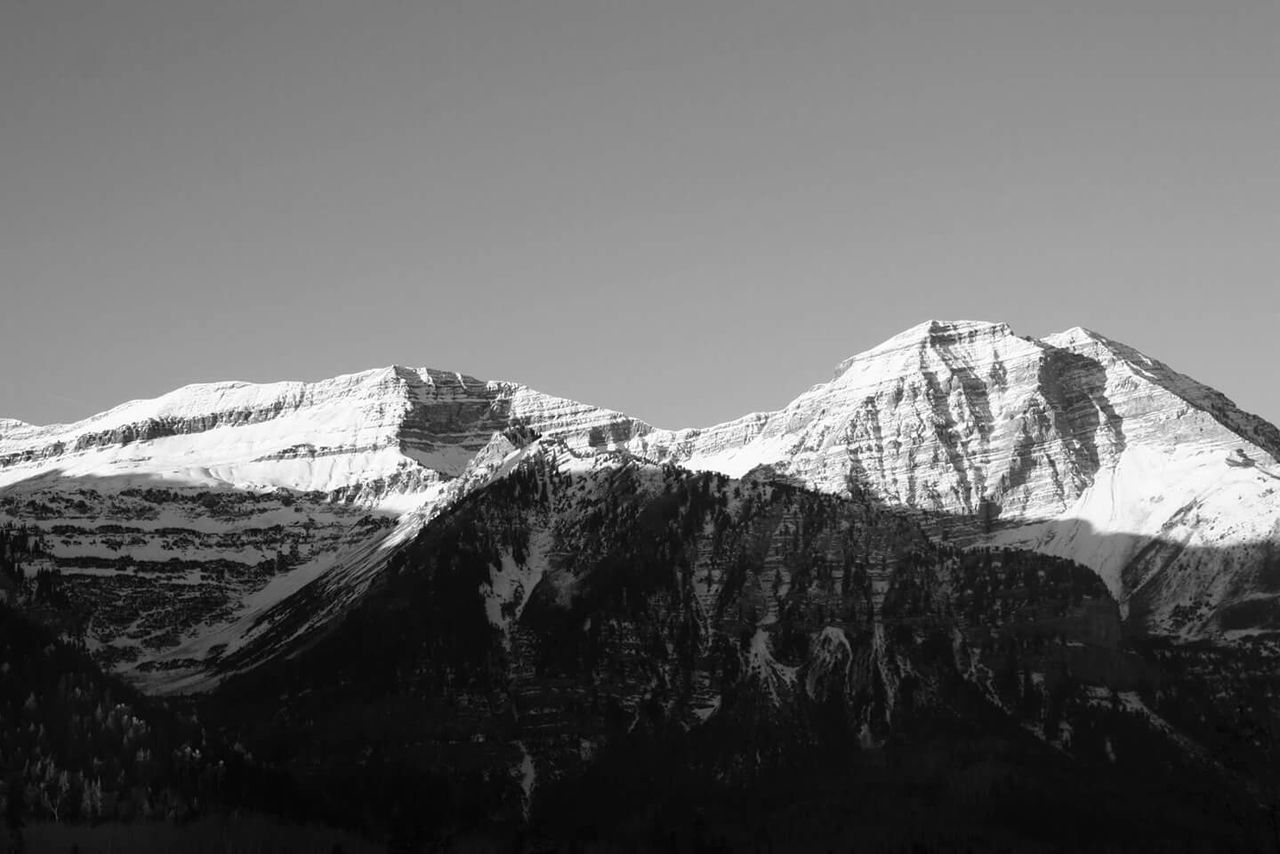 Scenic view of snow covered mountains against clear sky