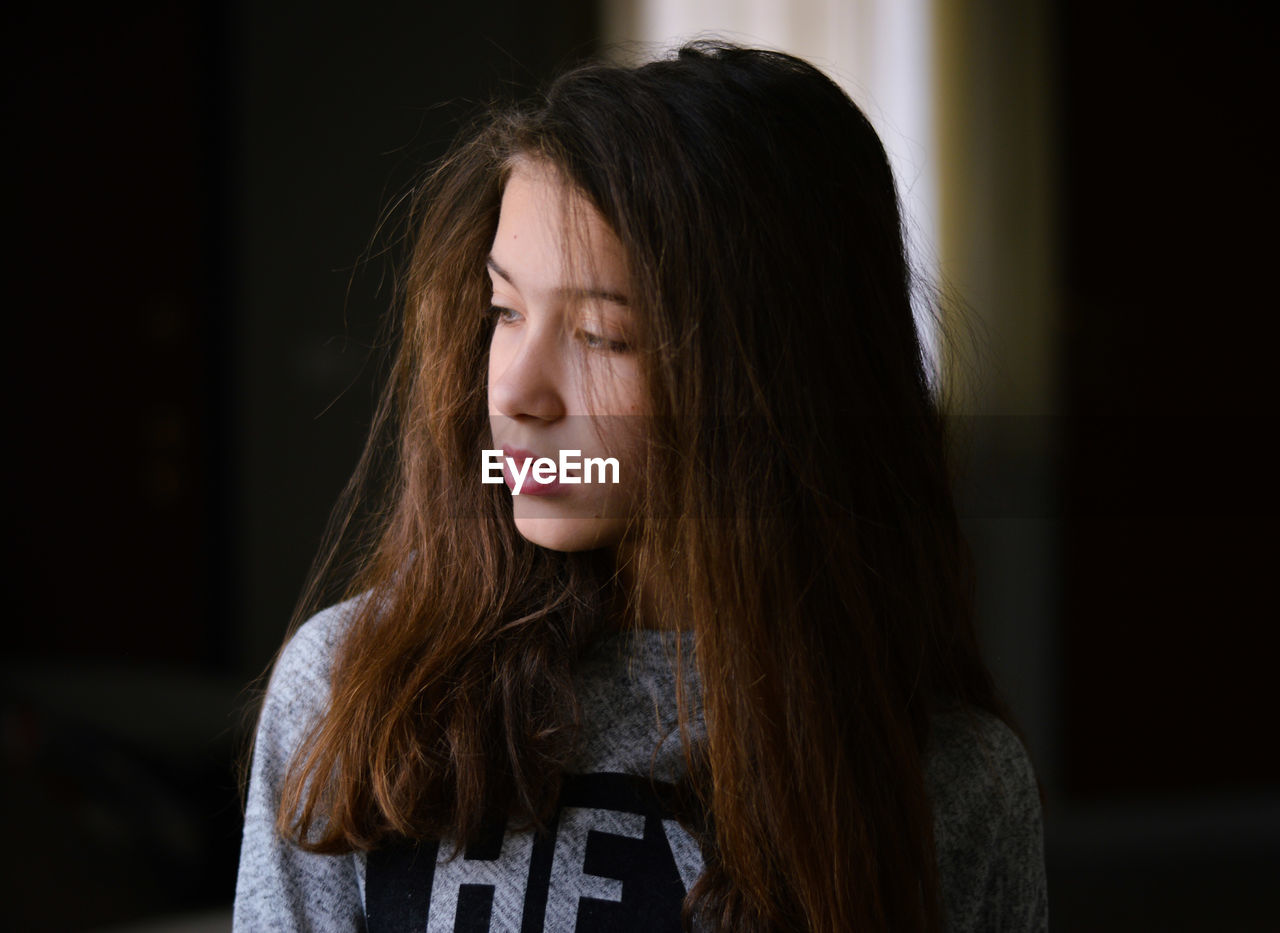 Close-up of woman looking away while standing indoors