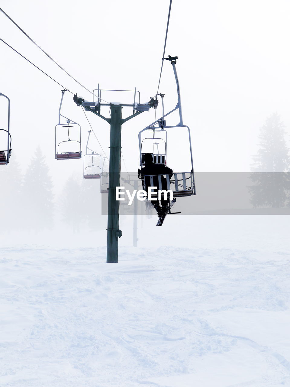 OVERHEAD CABLE CAR IN SNOW COVERED FIELD