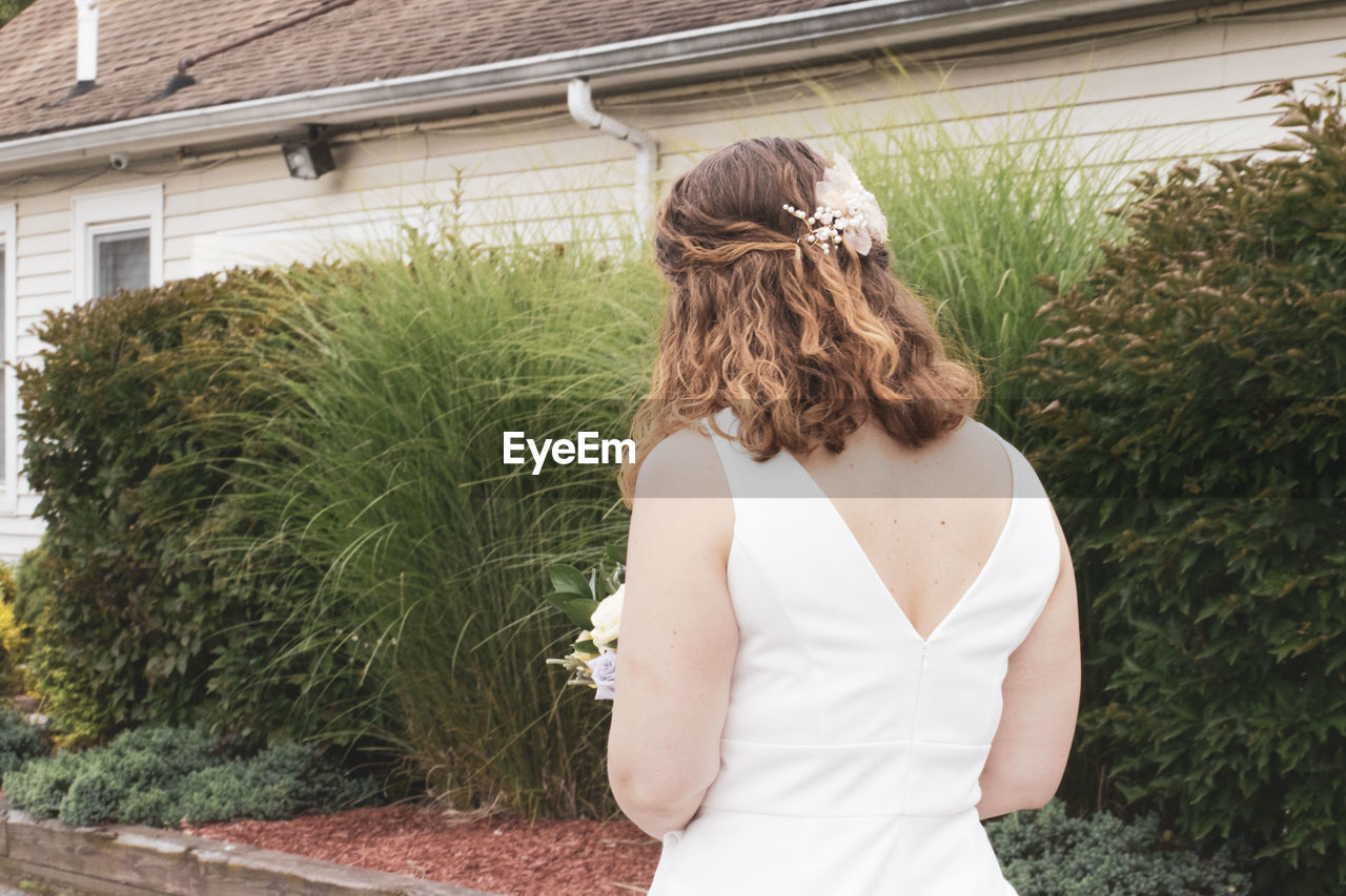 REAR VIEW OF WOMAN STANDING IN PARK