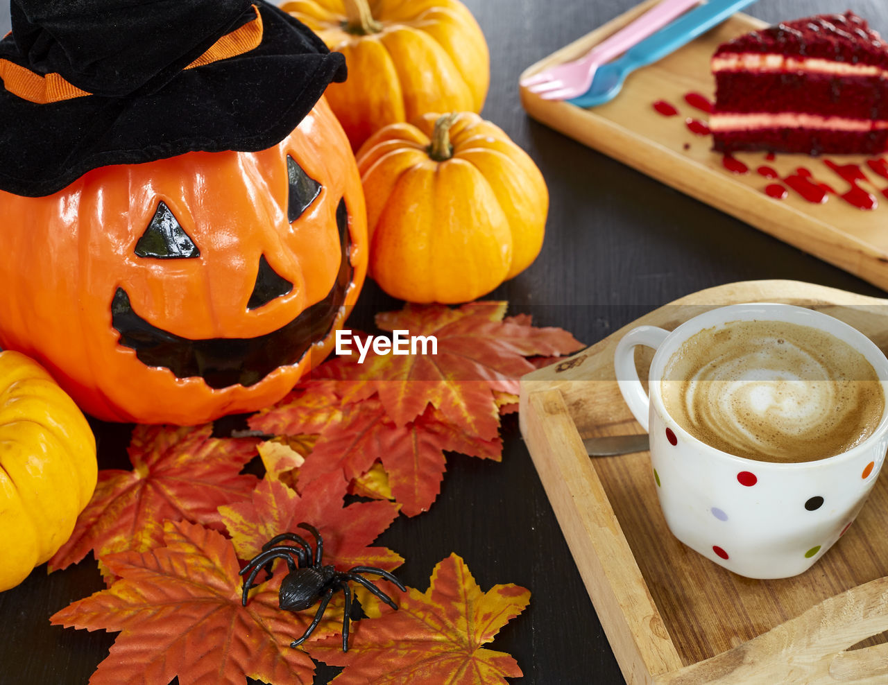 High angle view of jack o lantern with food and autumn leaves on table