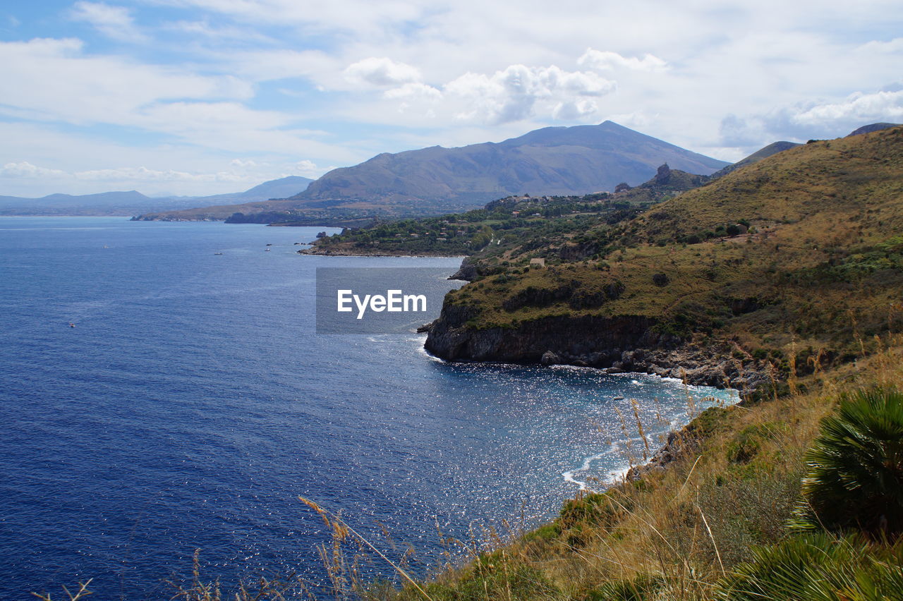 Scenic view of sea and mountains against sky