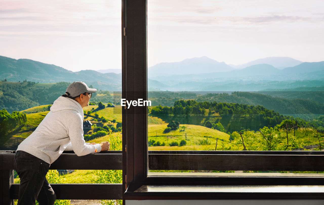 Man on balcony looking at mountain view