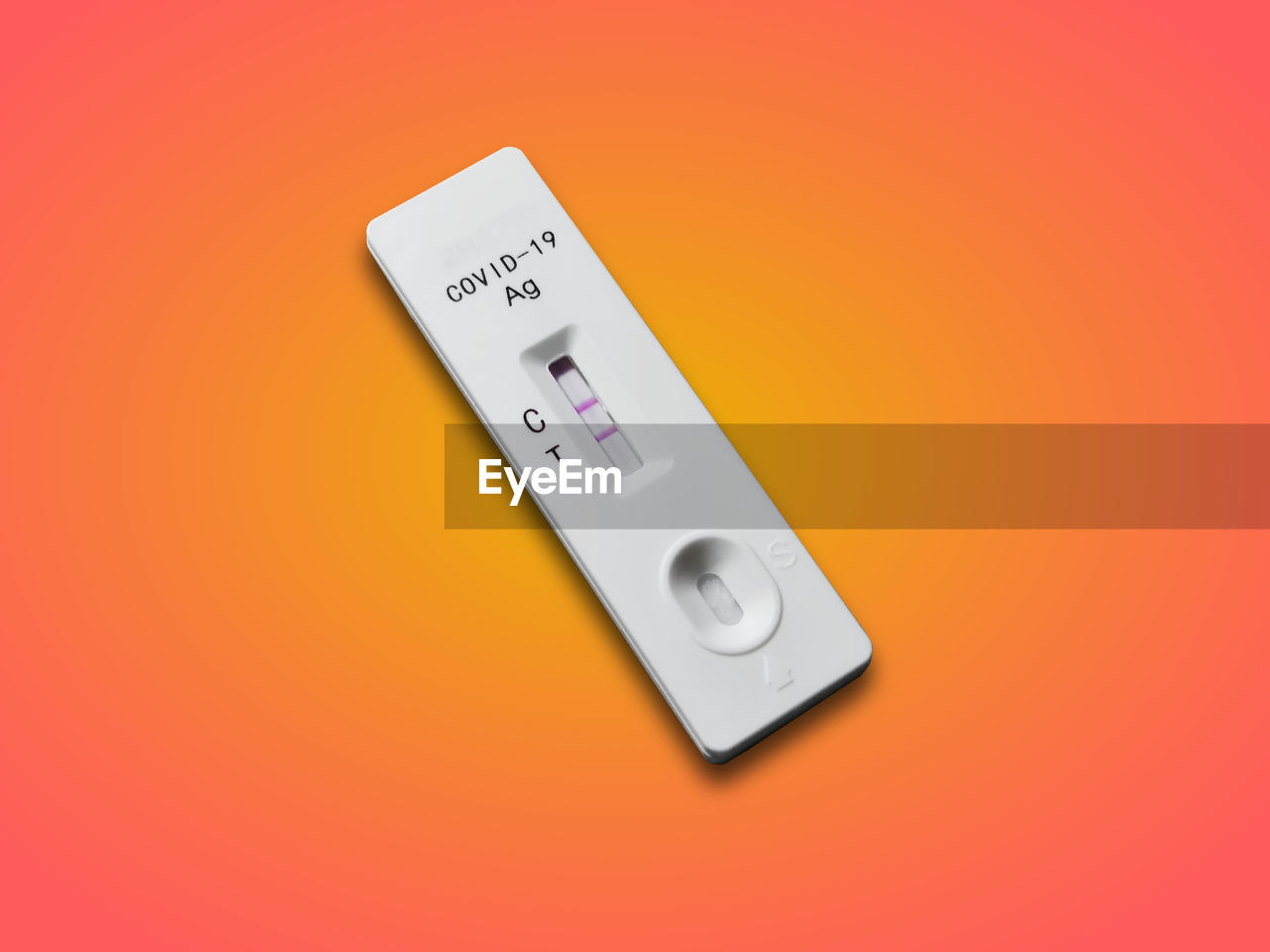 Rapid antigen test kit showing two lines as positive result of covid-19 isolated on orange