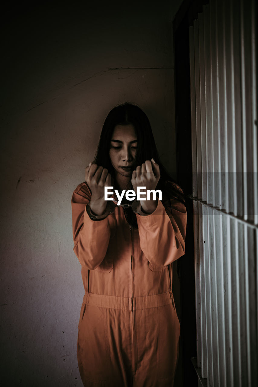 PORTRAIT OF A YOUNG MAN STANDING AGAINST WALL