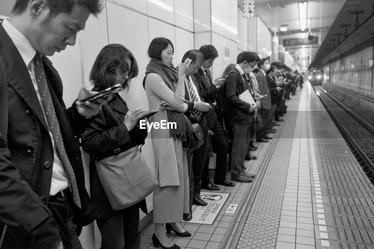 PEOPLE STANDING ON SUBWAY STATION