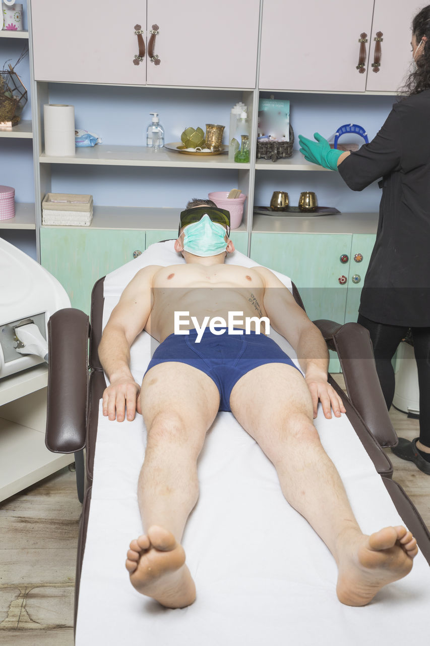 Beautician working with mask and protective screen for the virus covid