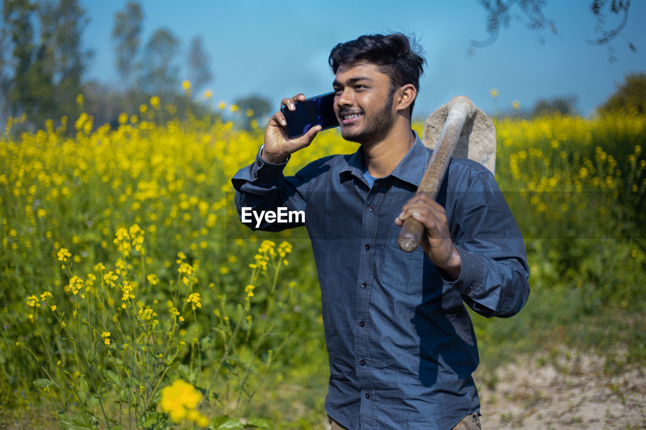 FULL LENGTH OF YOUNG MAN HOLDING YELLOW FLOWER