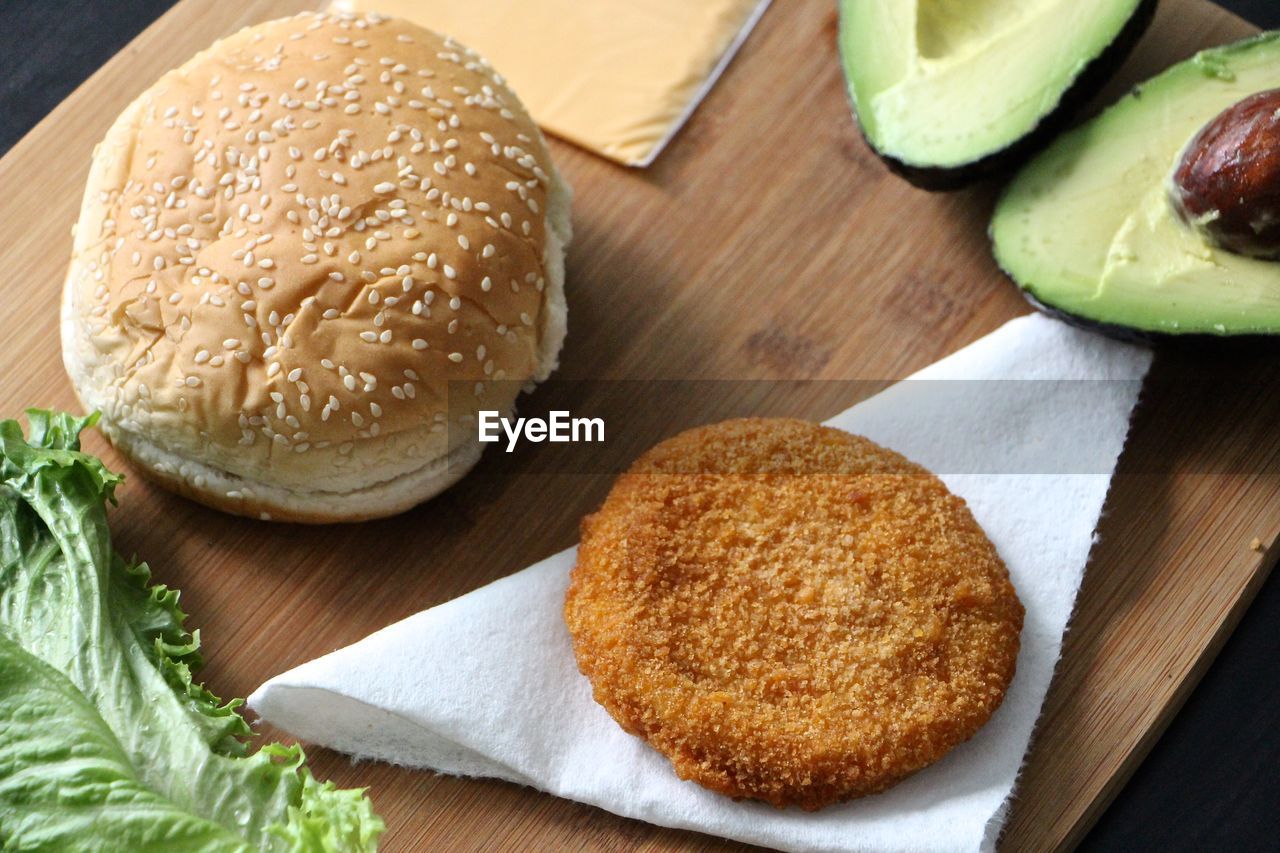 High angle view of sesame seed bun and patty on table