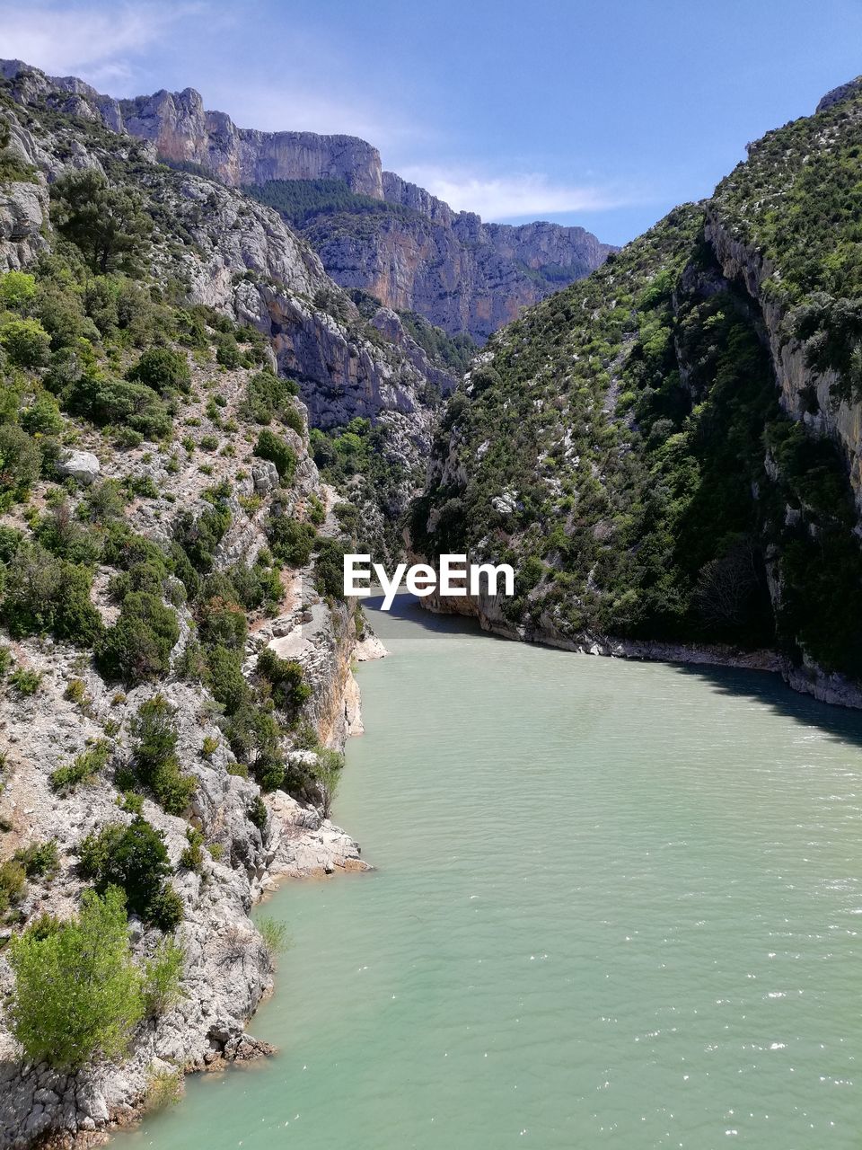 Scenic view of river amidst mountains against sky