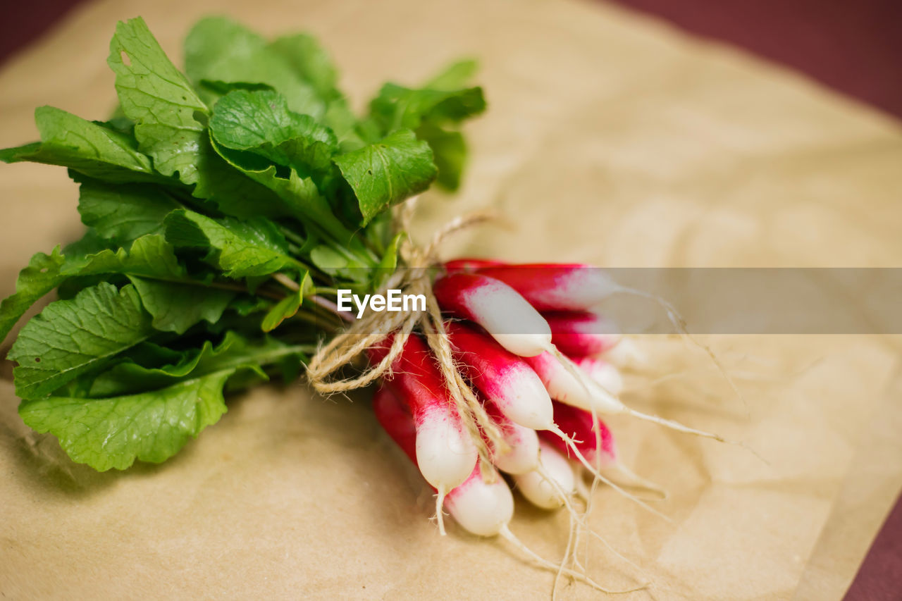 A bunch of freshly picked red radishes on crumpled kraft paper. growing vegetables, harvesting.