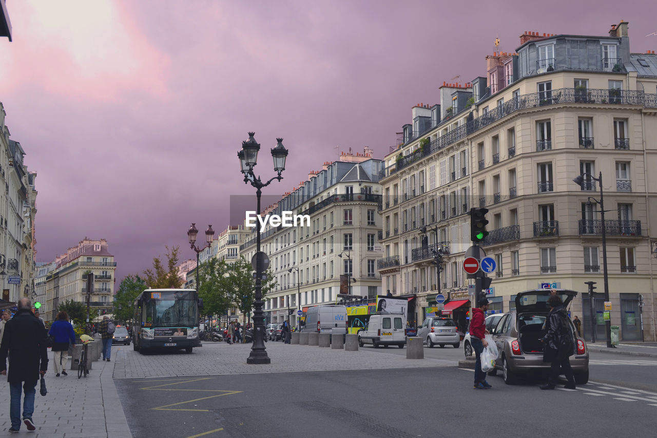 People on street in city against sky