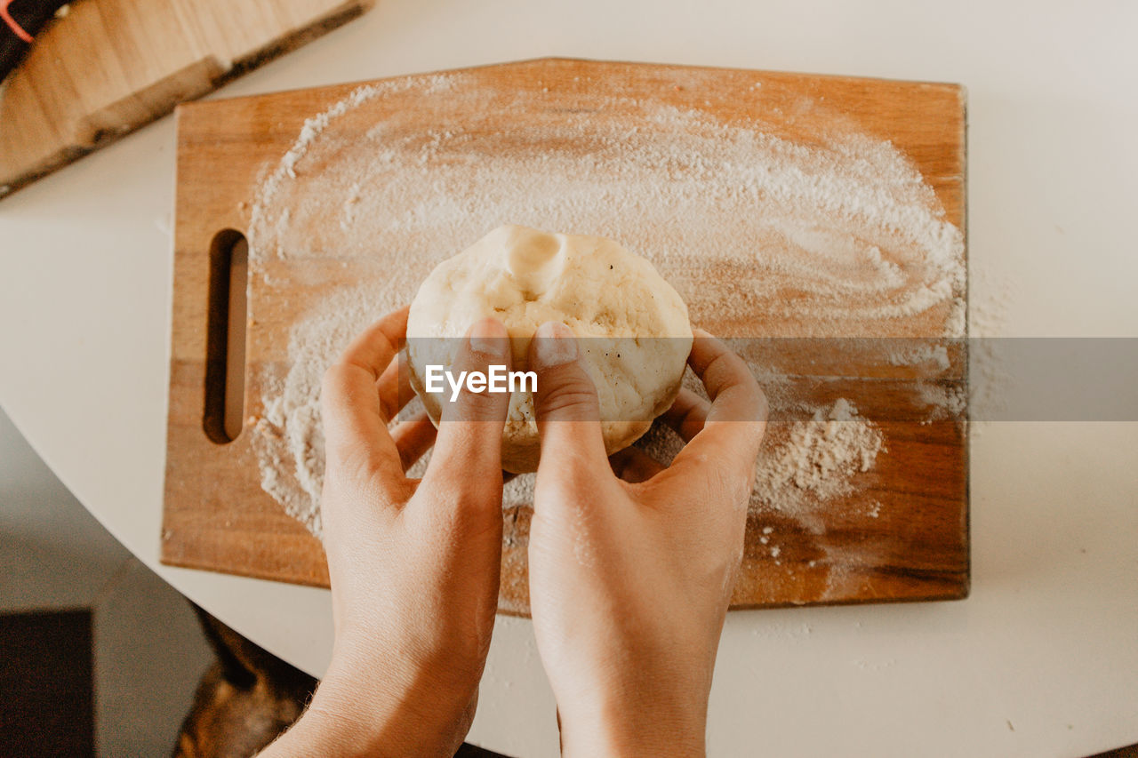 Cropped hands kneading dough 