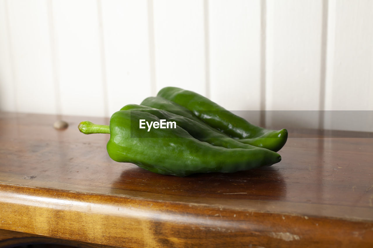 Pair of poblano peppers on a wooden table