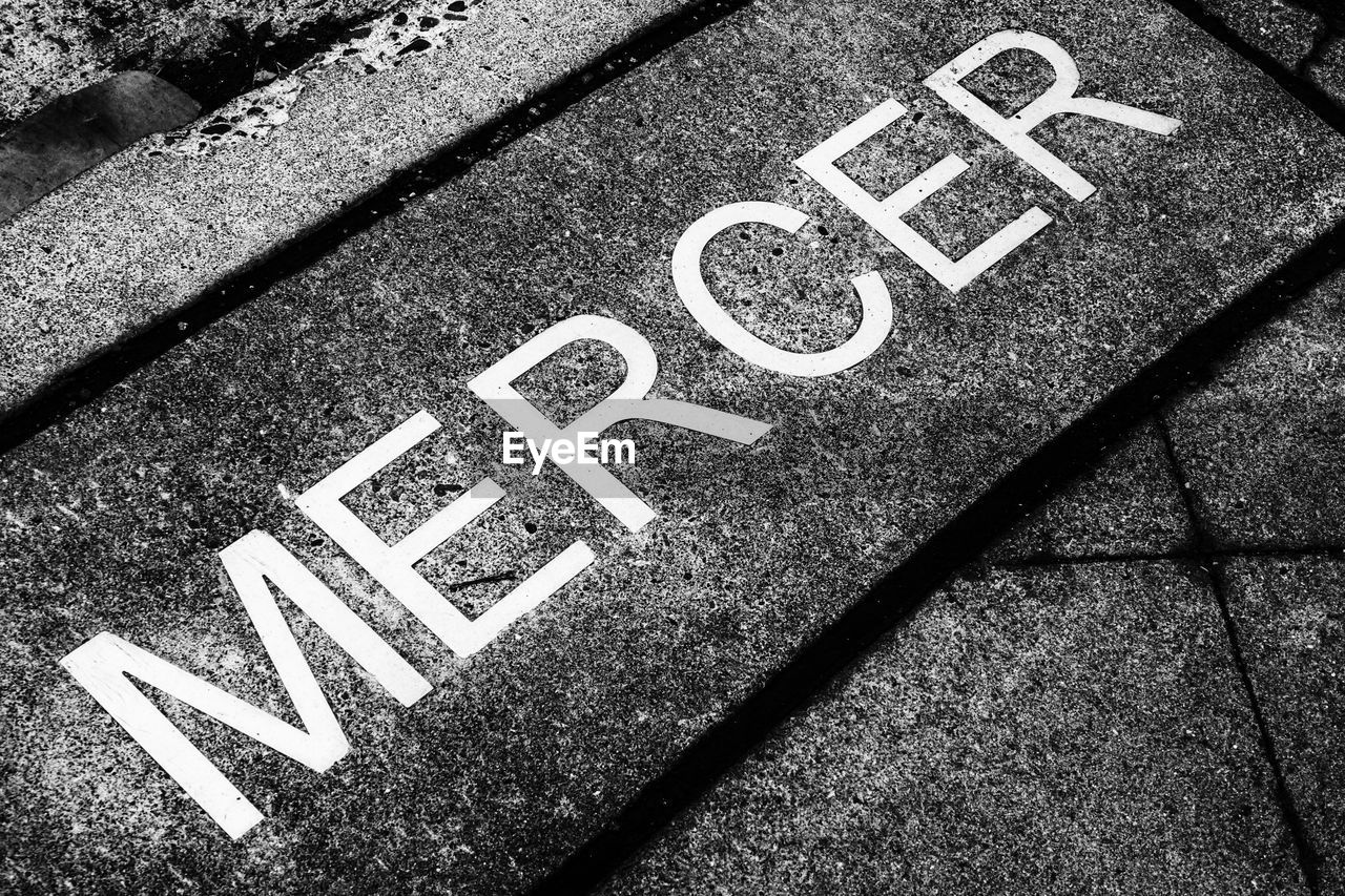 HIGH ANGLE VIEW OF ARROW SYMBOL ON STREET