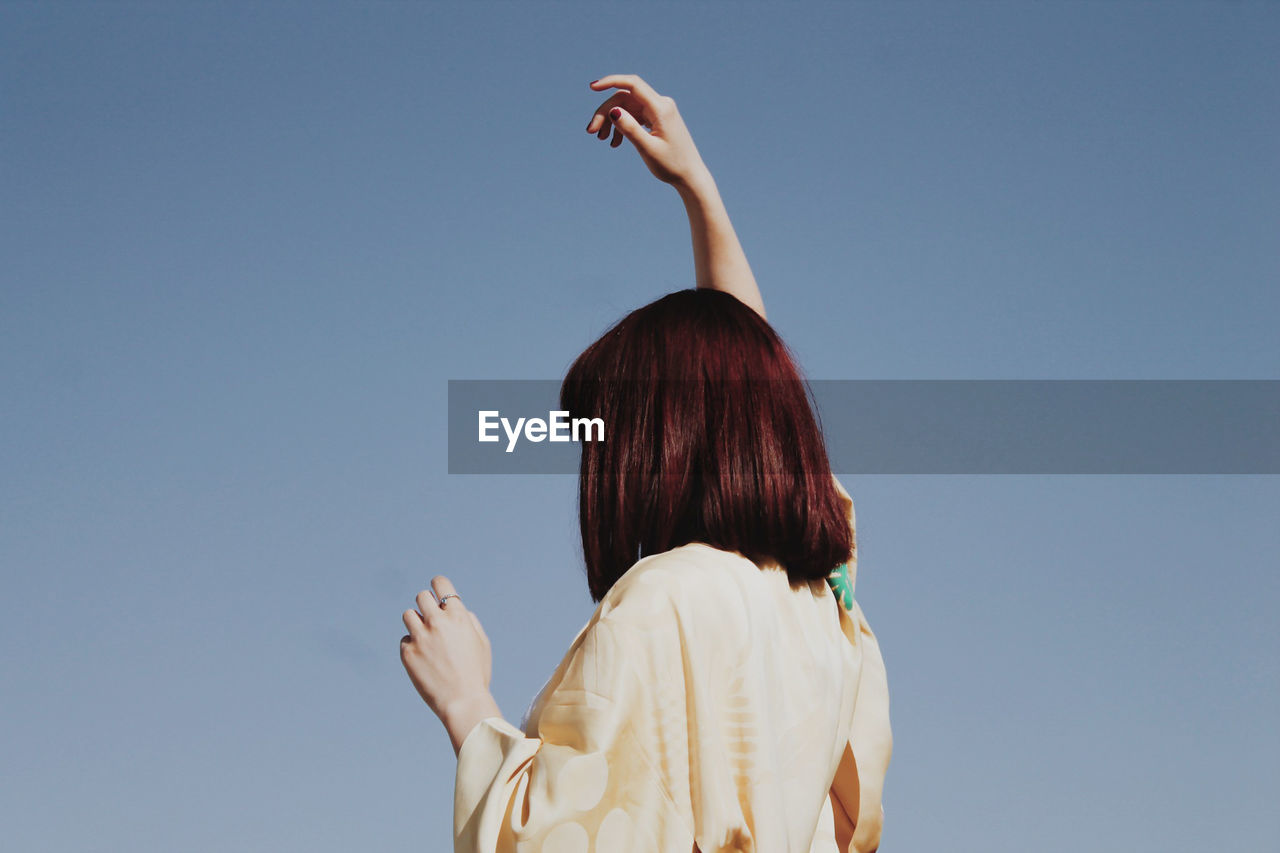 Low angle view of woman against clear sky