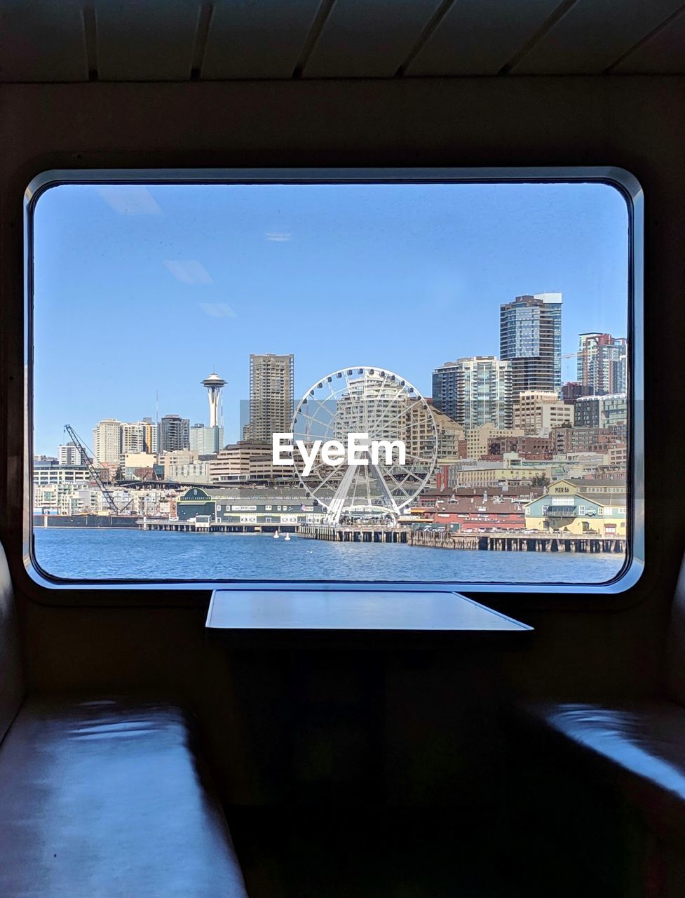 BUILDINGS AGAINST SKY SEEN FROM GLASS WINDOW