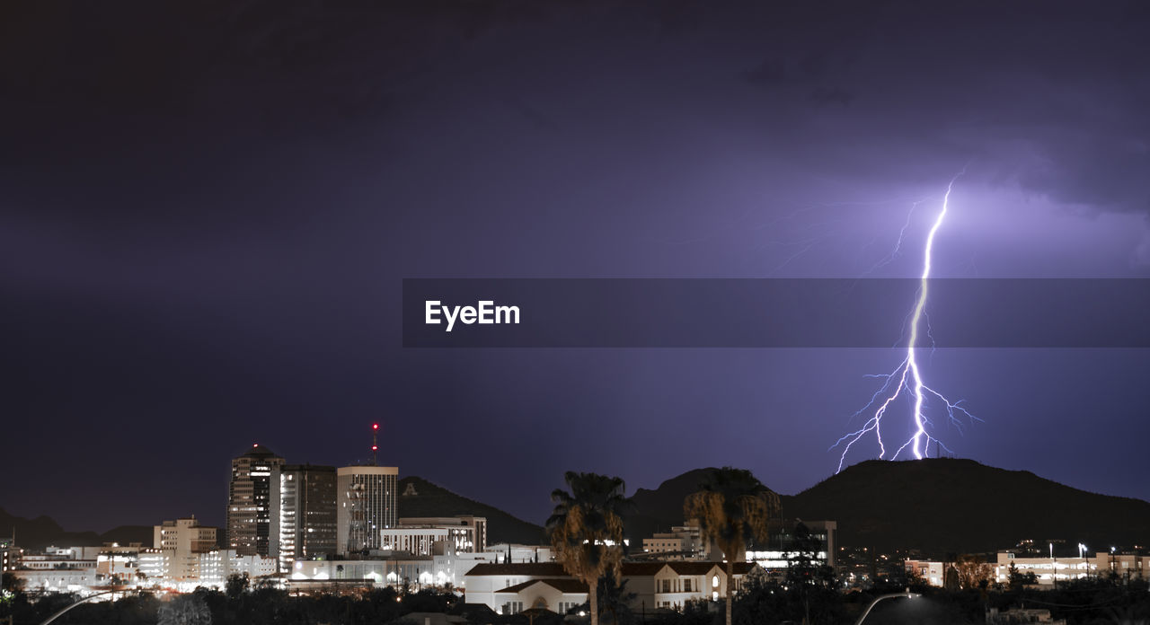 LIGHTNING IN SKY OVER CITY BUILDINGS