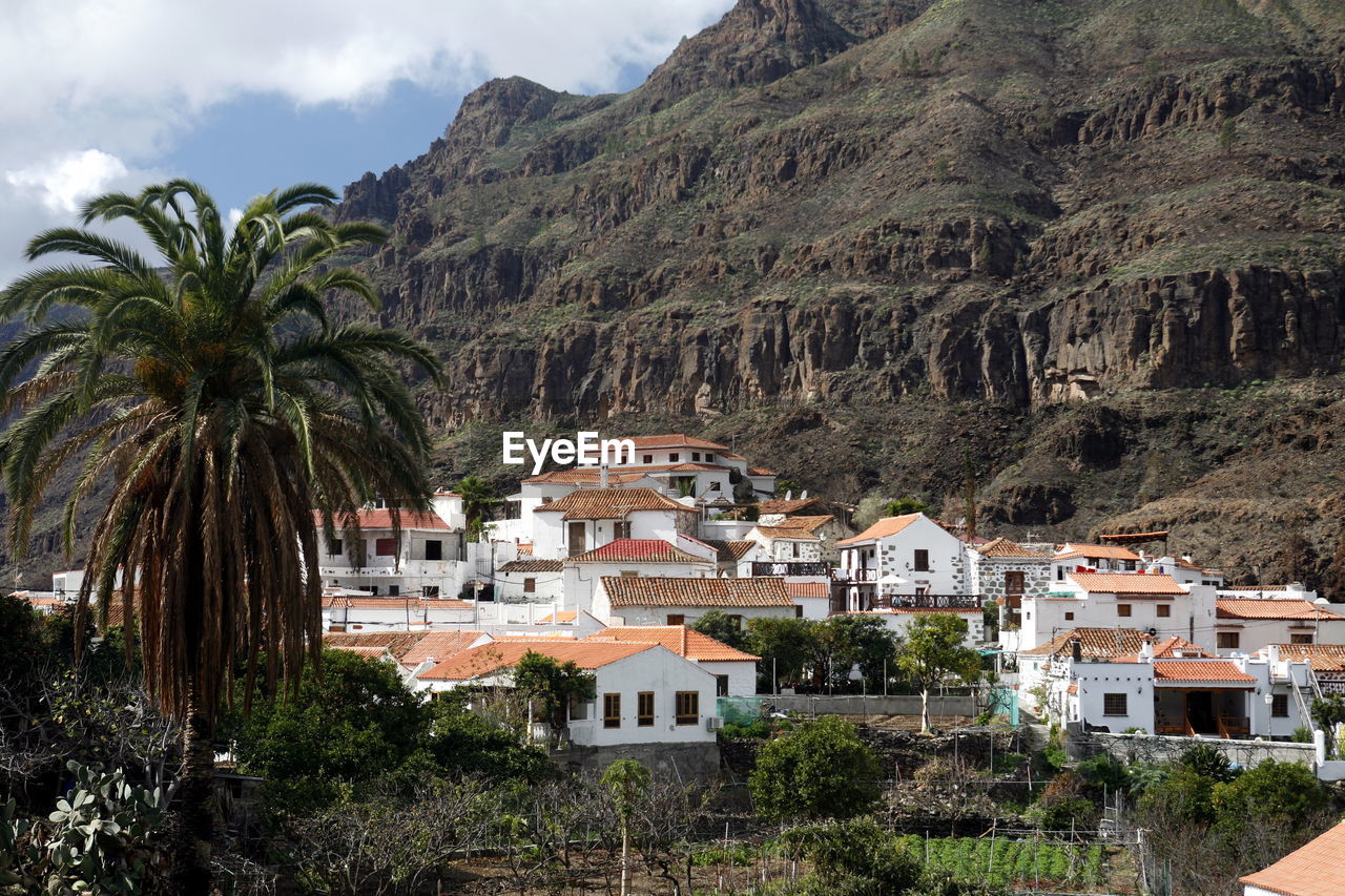 High angle view of village and field against mountain