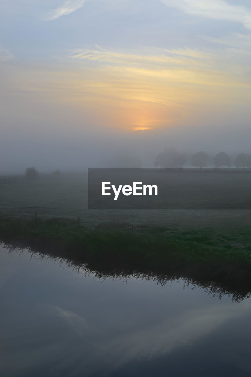 SCENIC VIEW OF FOG AGAINST SKY AT SUNSET