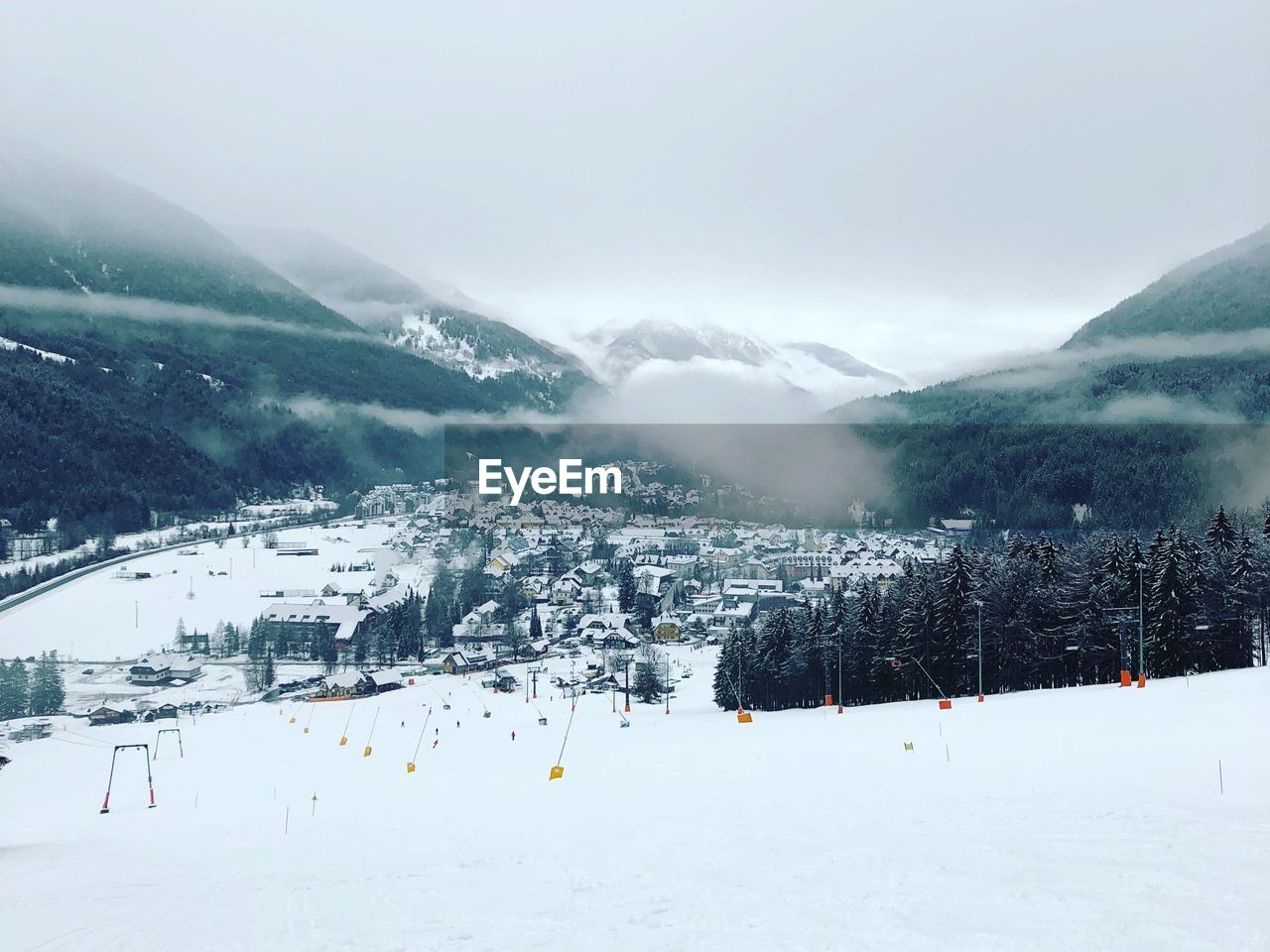 Ski lift over snowcapped mountains against sky