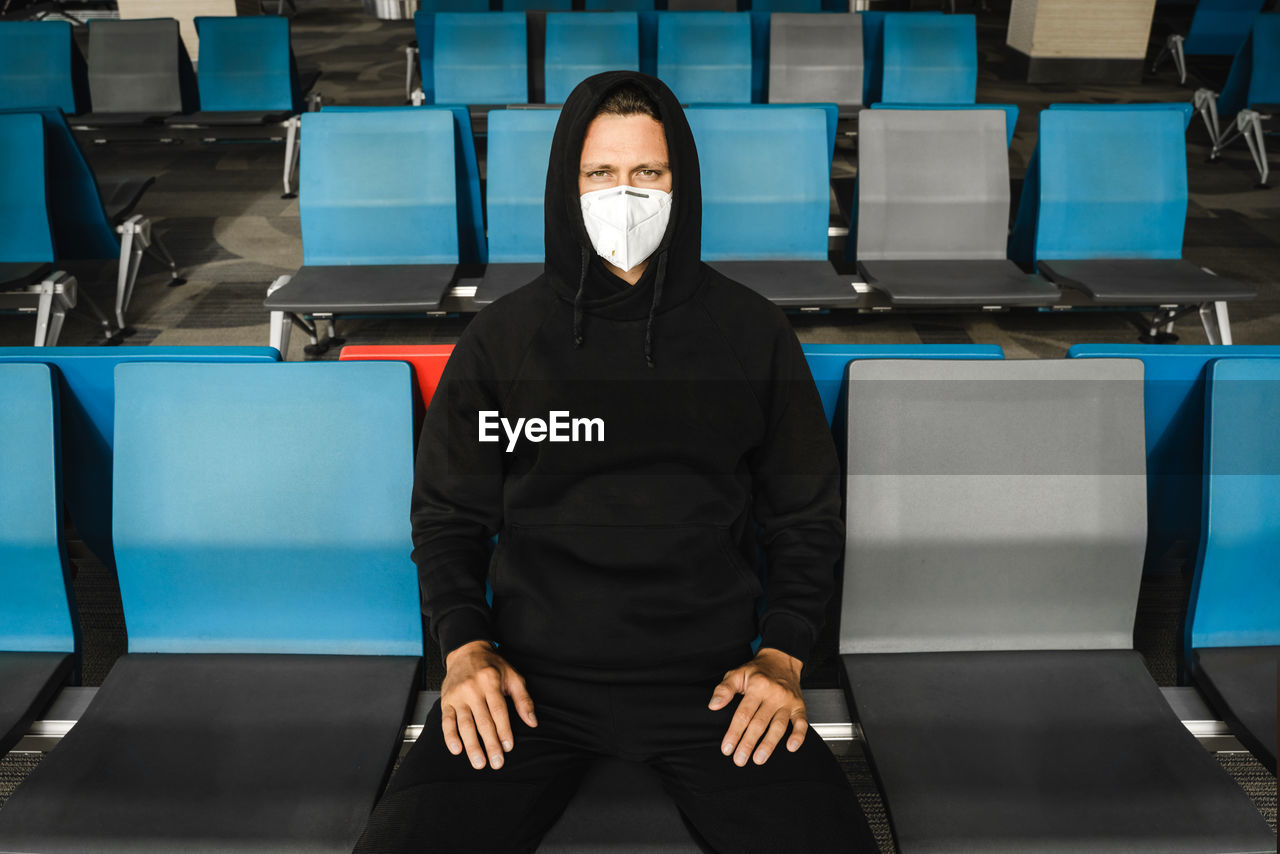 Portrait of man wearing mask while sitting in waiting room