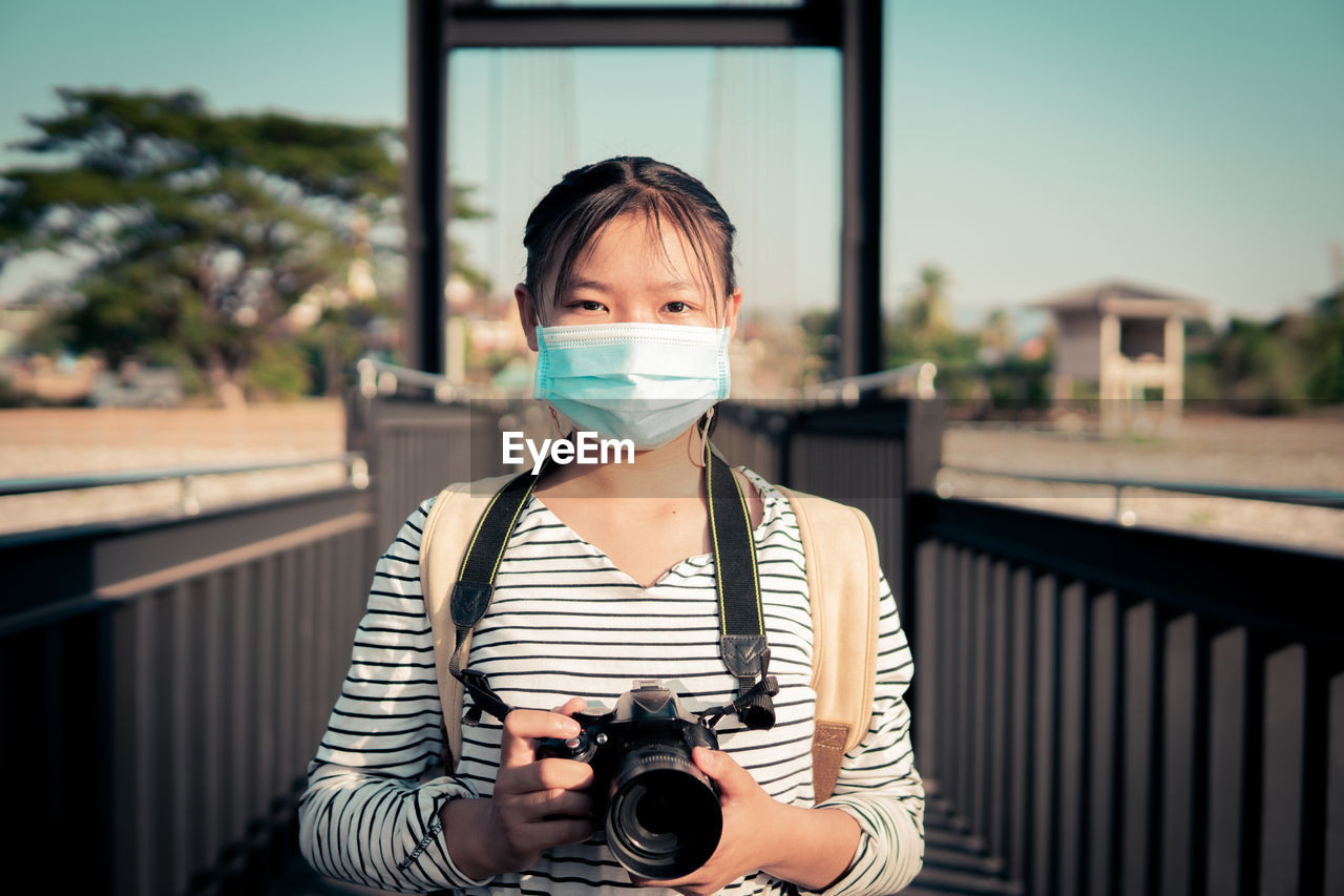 PORTRAIT OF MAN HOLDING CAMERA