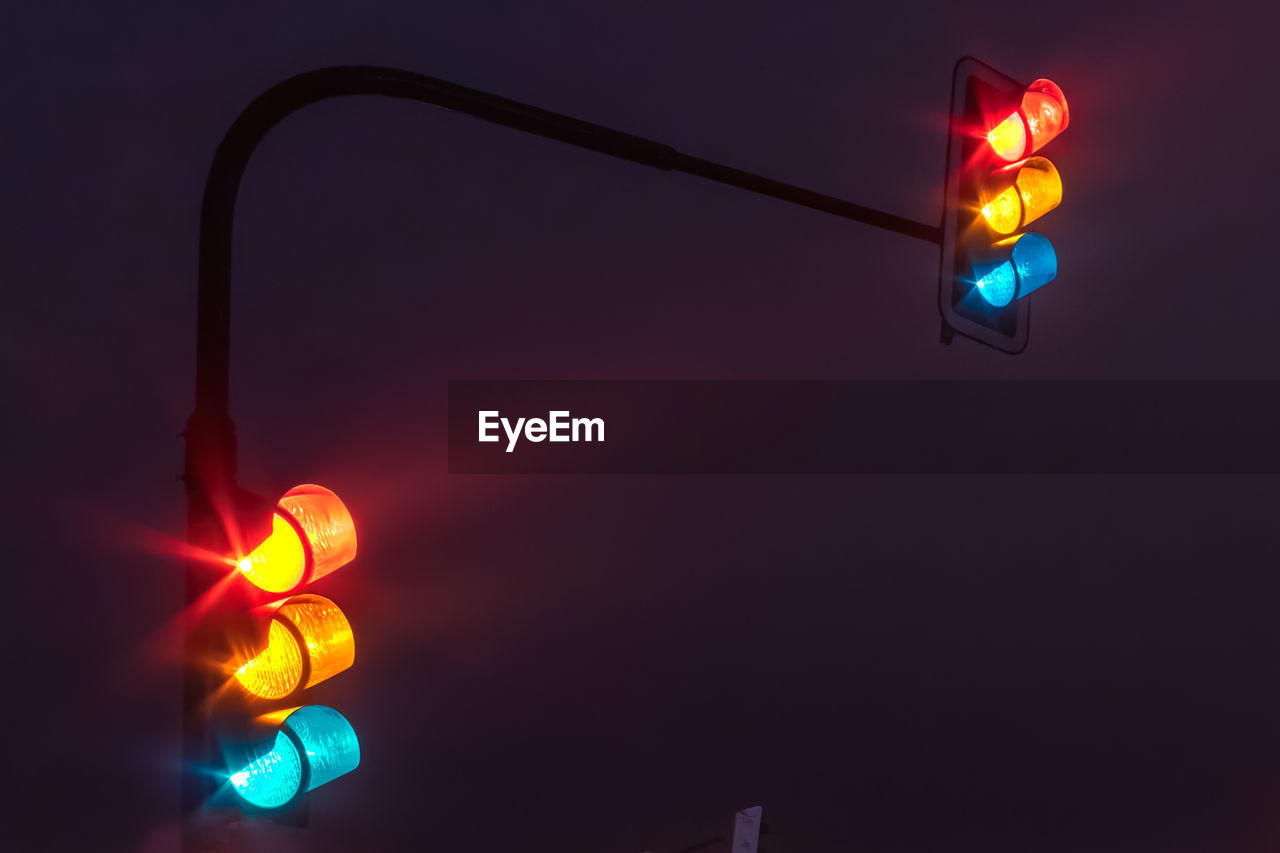 Low angle view of stoplights at night
