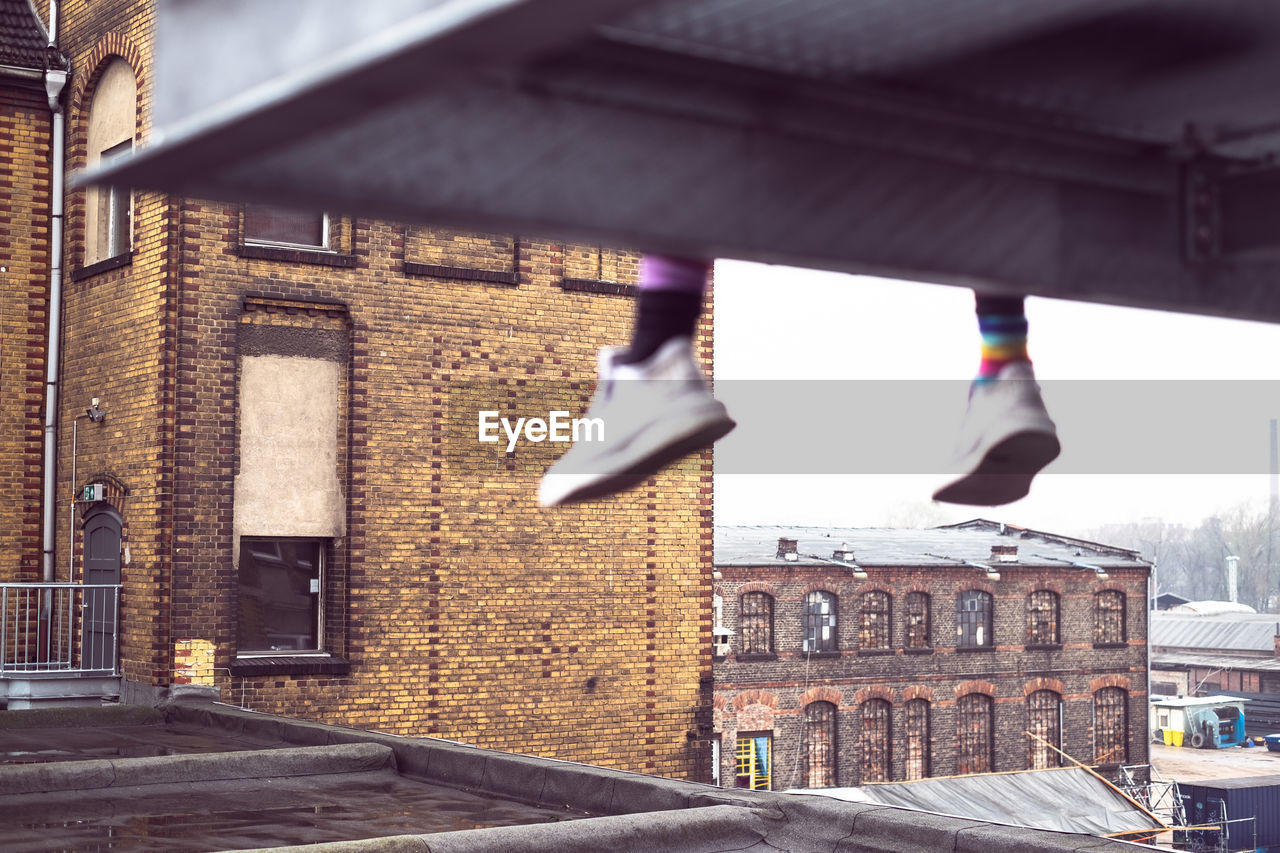 LOW SECTION OF PERSON WALKING ON BUILDING IN CITY