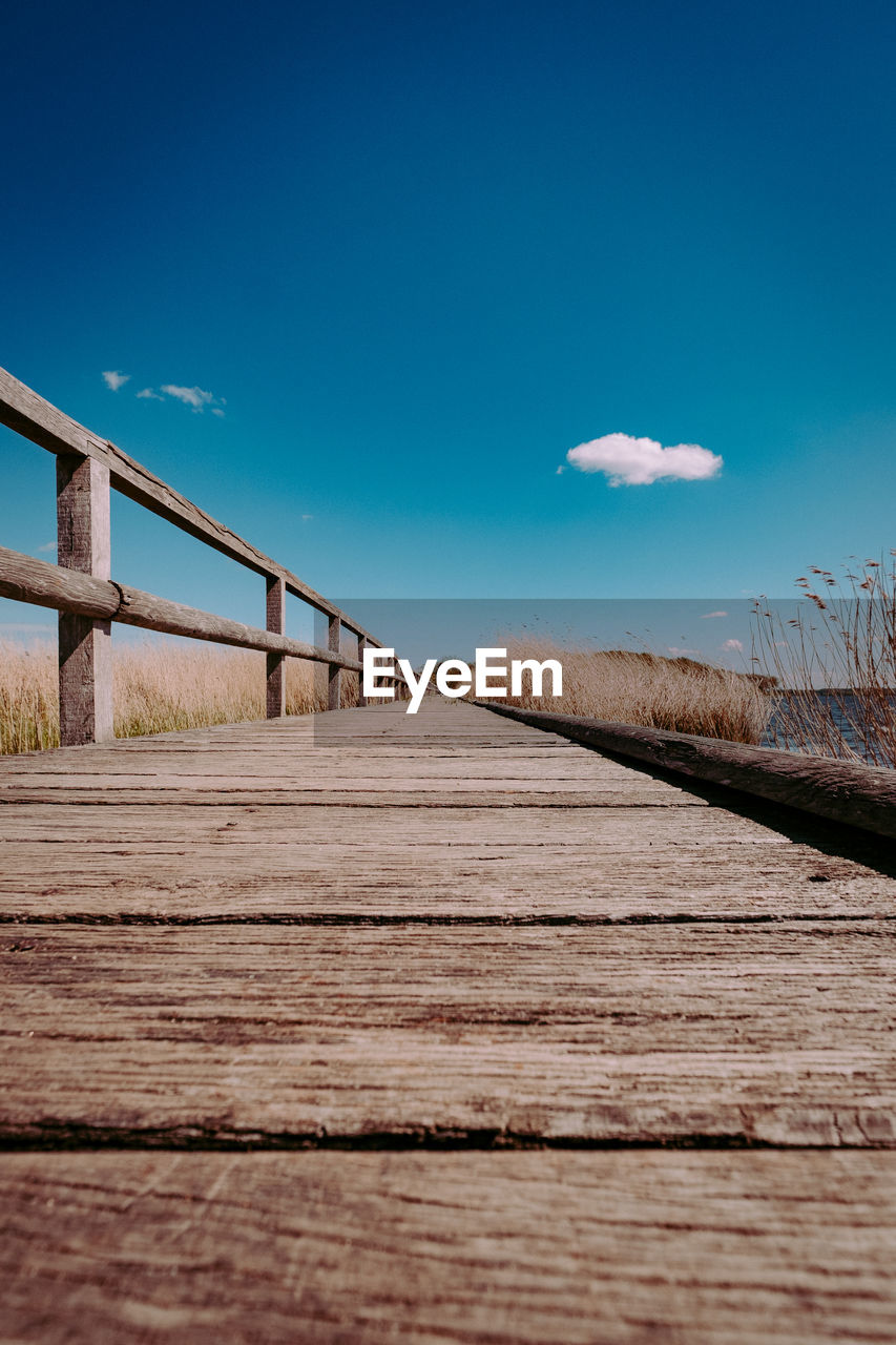 SURFACE LEVEL OF BOARDWALK AGAINST SKY