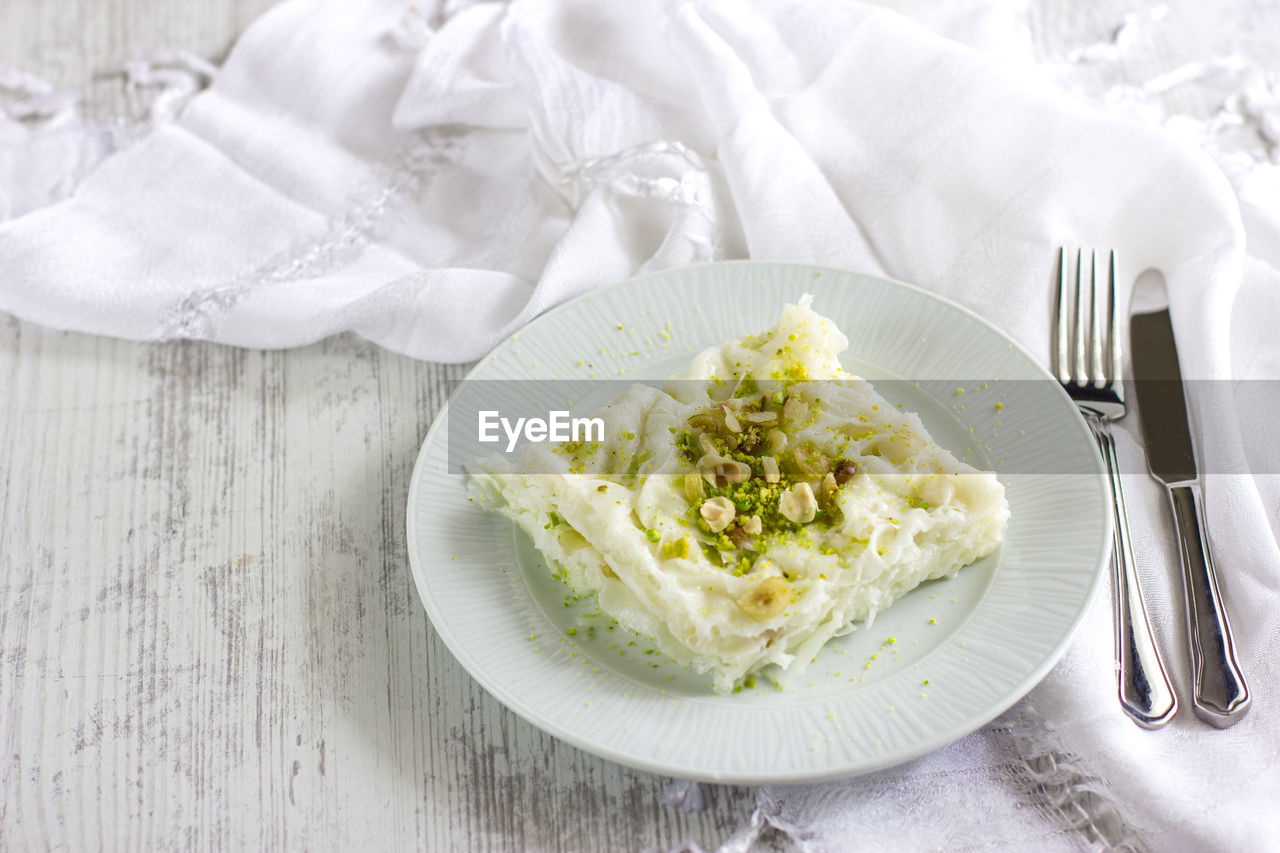 Traditional turkish meal - gullac. milk dessert sprinkled with ground nuts and pistachios. 