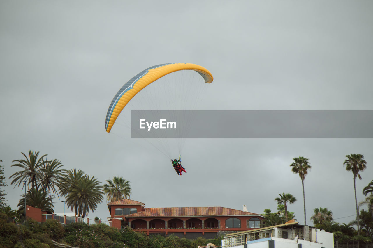 LOW ANGLE VIEW OF PARAGLIDING AGAINST SKY