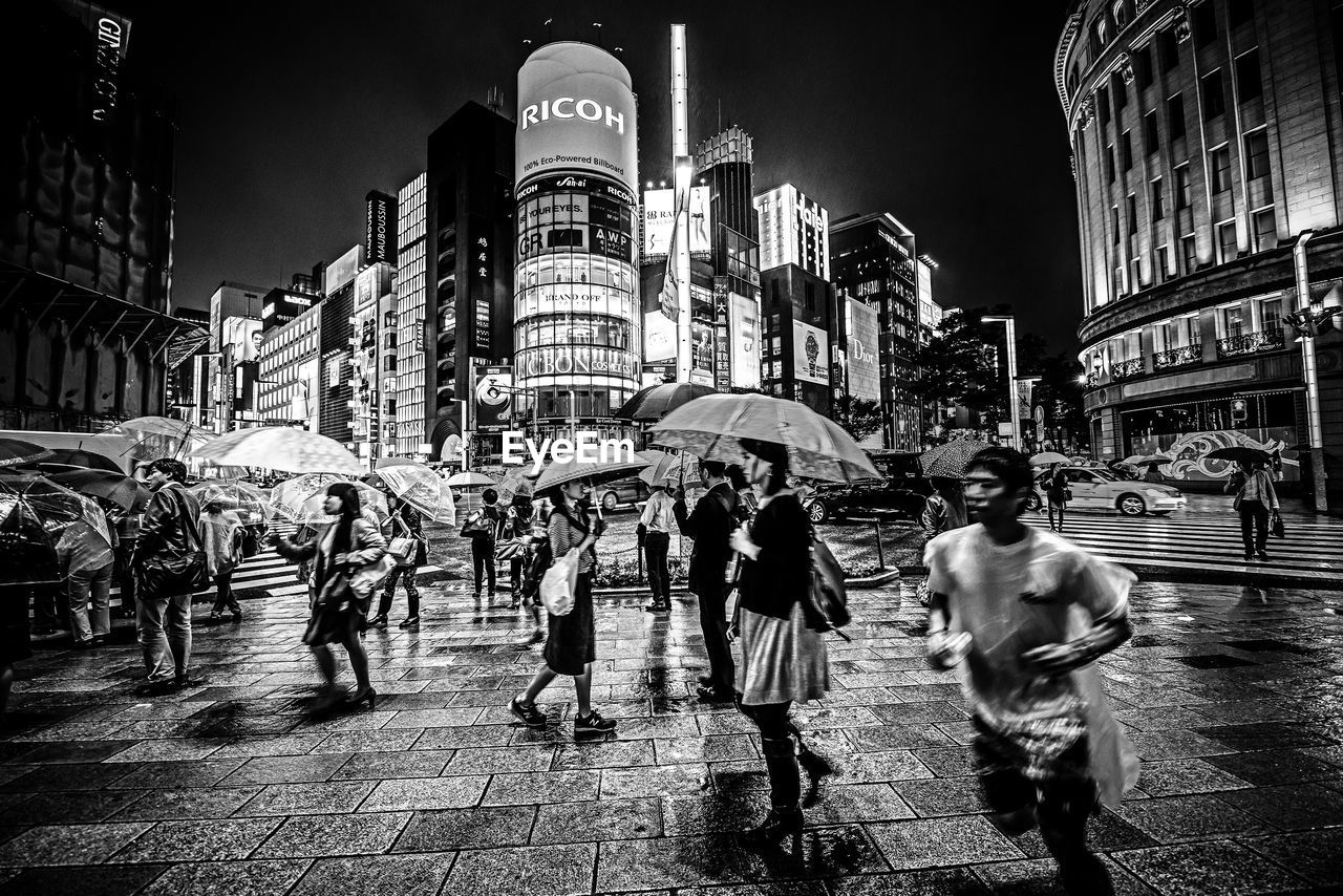 PEOPLE ON ILLUMINATED CITY AT NIGHT