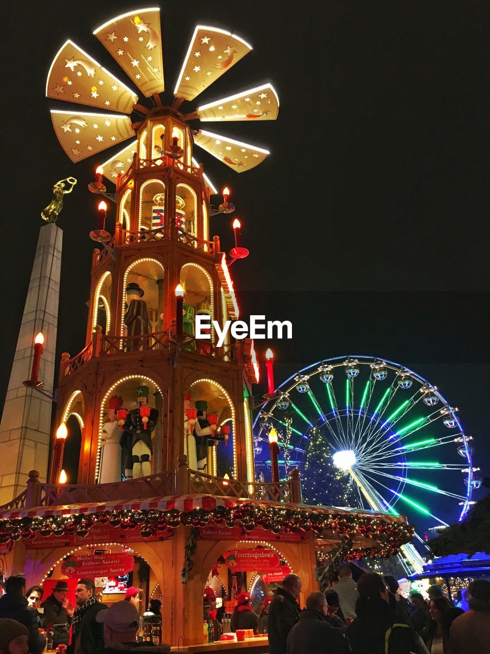 ILLUMINATED FERRIS WHEEL IN CITY AGAINST SKY