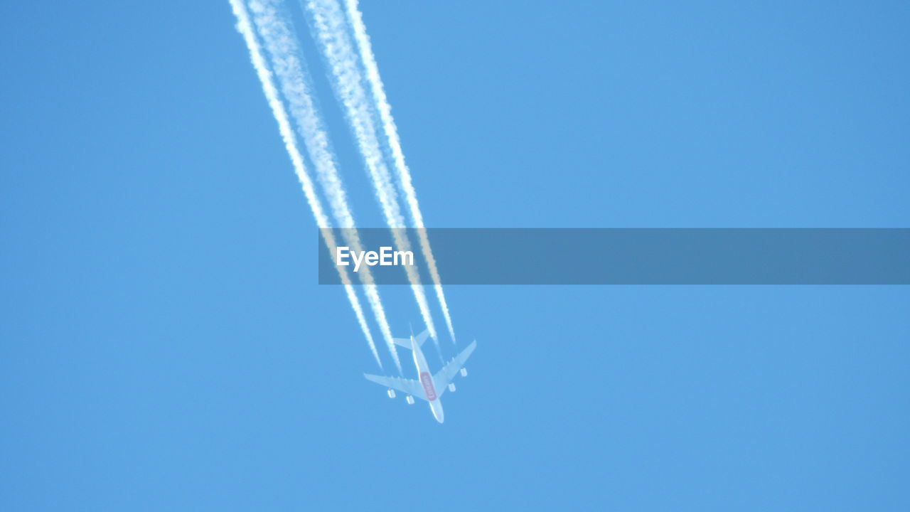 LOW ANGLE VIEW OF VAPOR TRAILS IN SKY