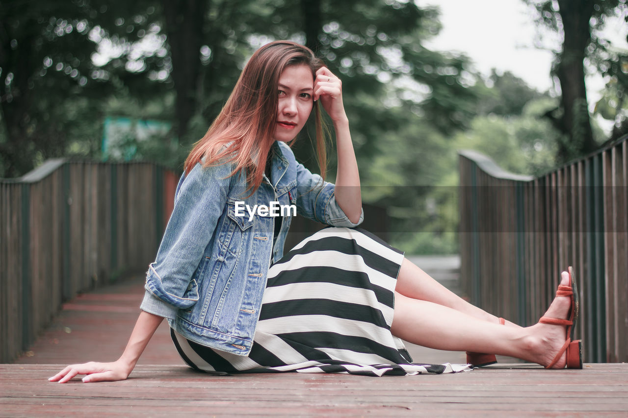 FULL LENGTH PORTRAIT OF WOMAN SITTING ON FLOOR