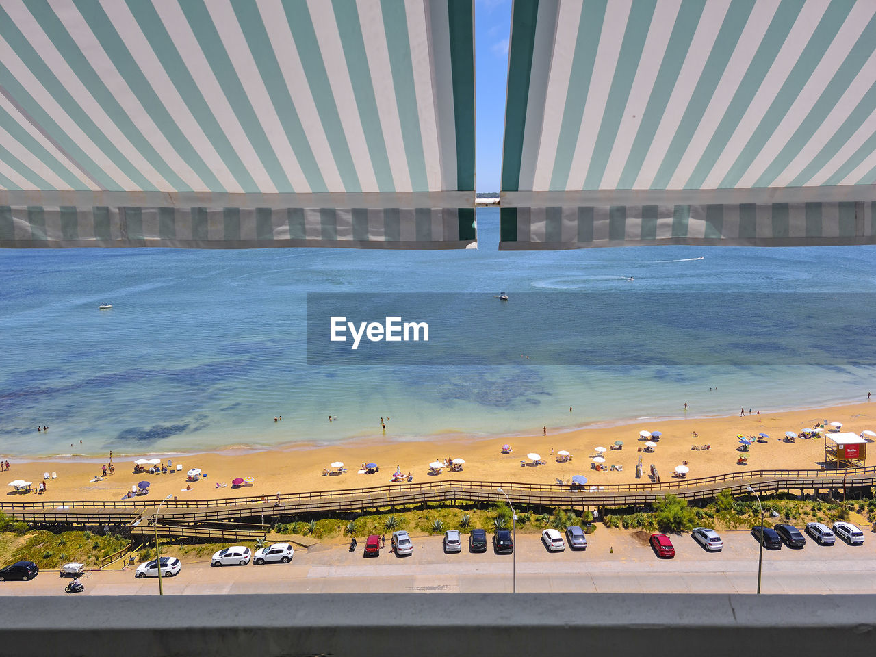 HIGH ANGLE VIEW OF PEOPLE AT SWIMMING POOL AGAINST SEA