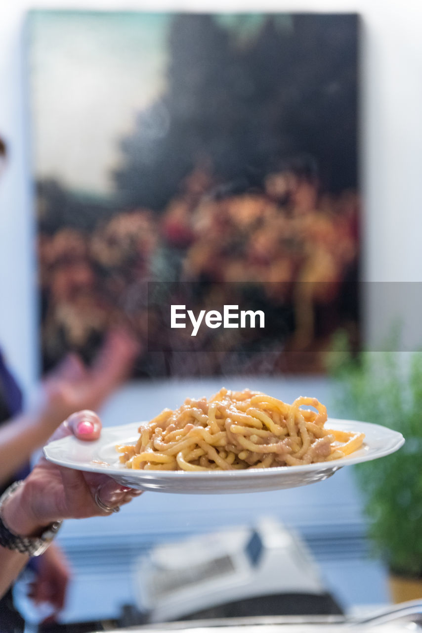 Cropped hand of woman holding bigoli pasta