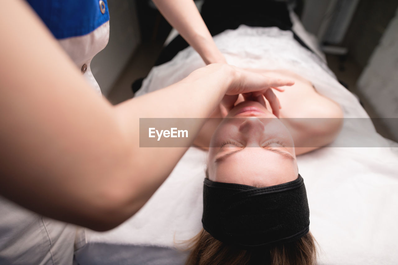 Cosmetic facial massage procedure. close-up of the face of a young woman lying on her back, doing a