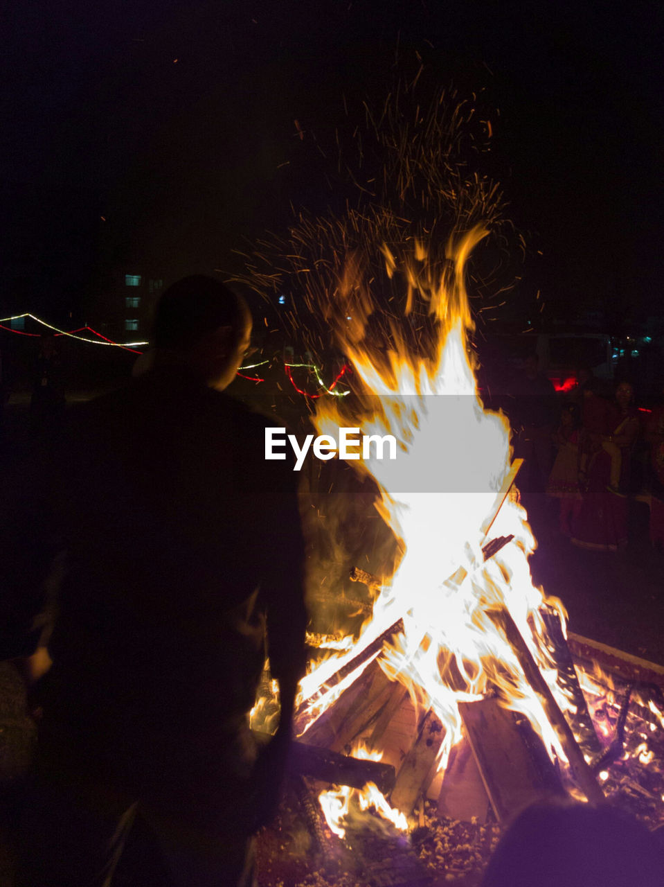 MAN WORKING IN FIRE AT NIGHT