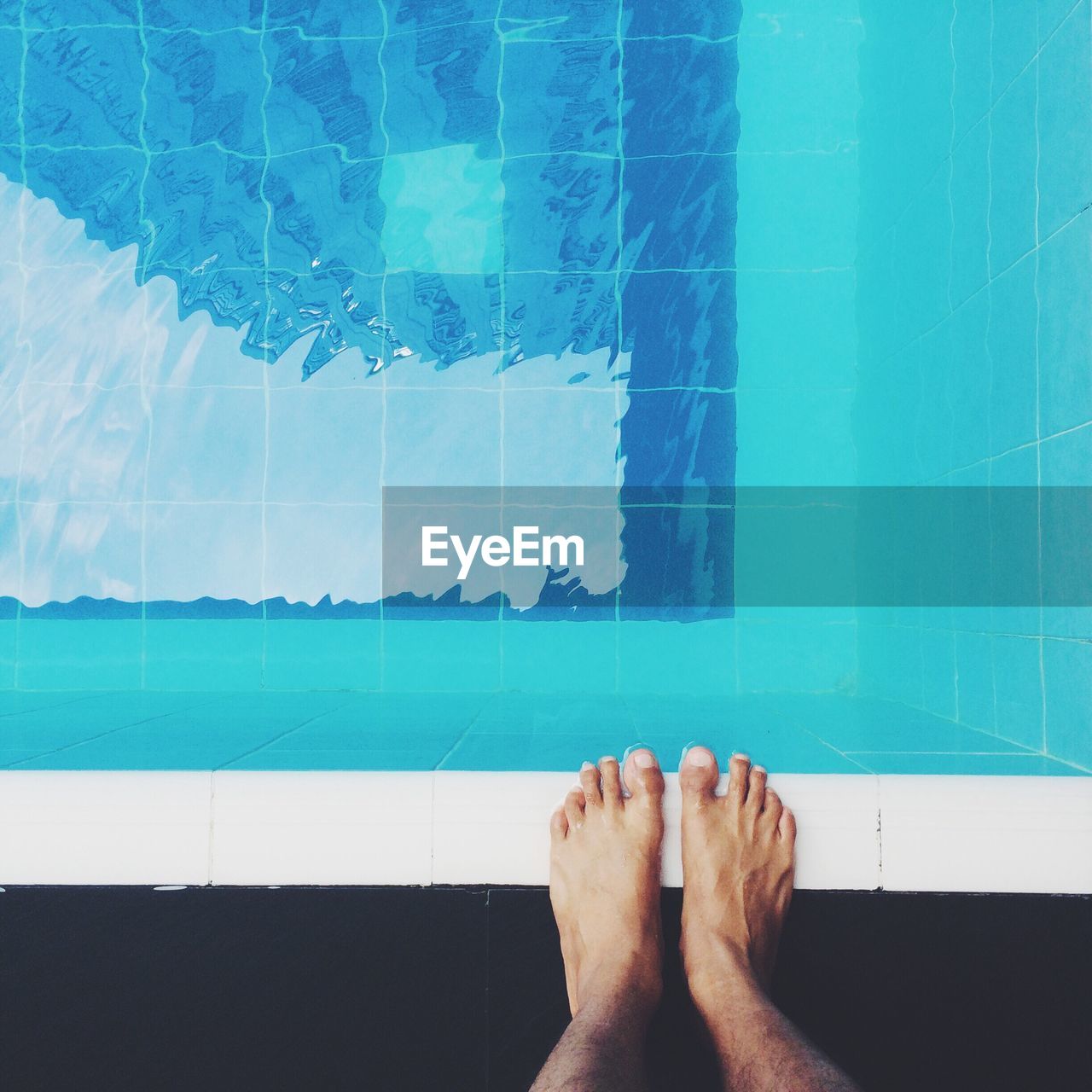 Low section of person standing on poolside