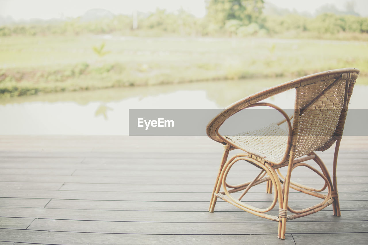 EMPTY CHAIRS AND TABLE ON LAKE