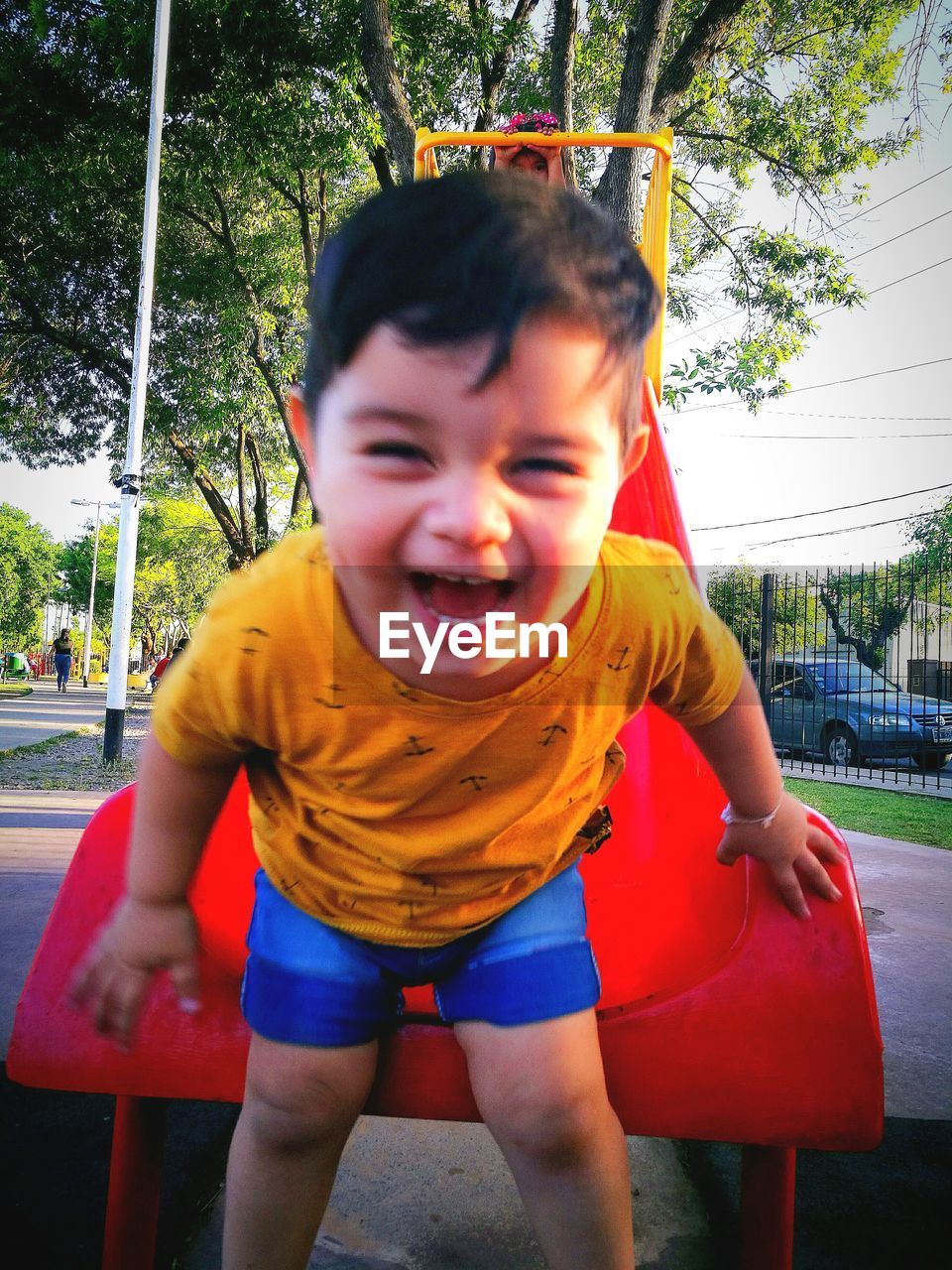 Happy boy playing on slide at playground