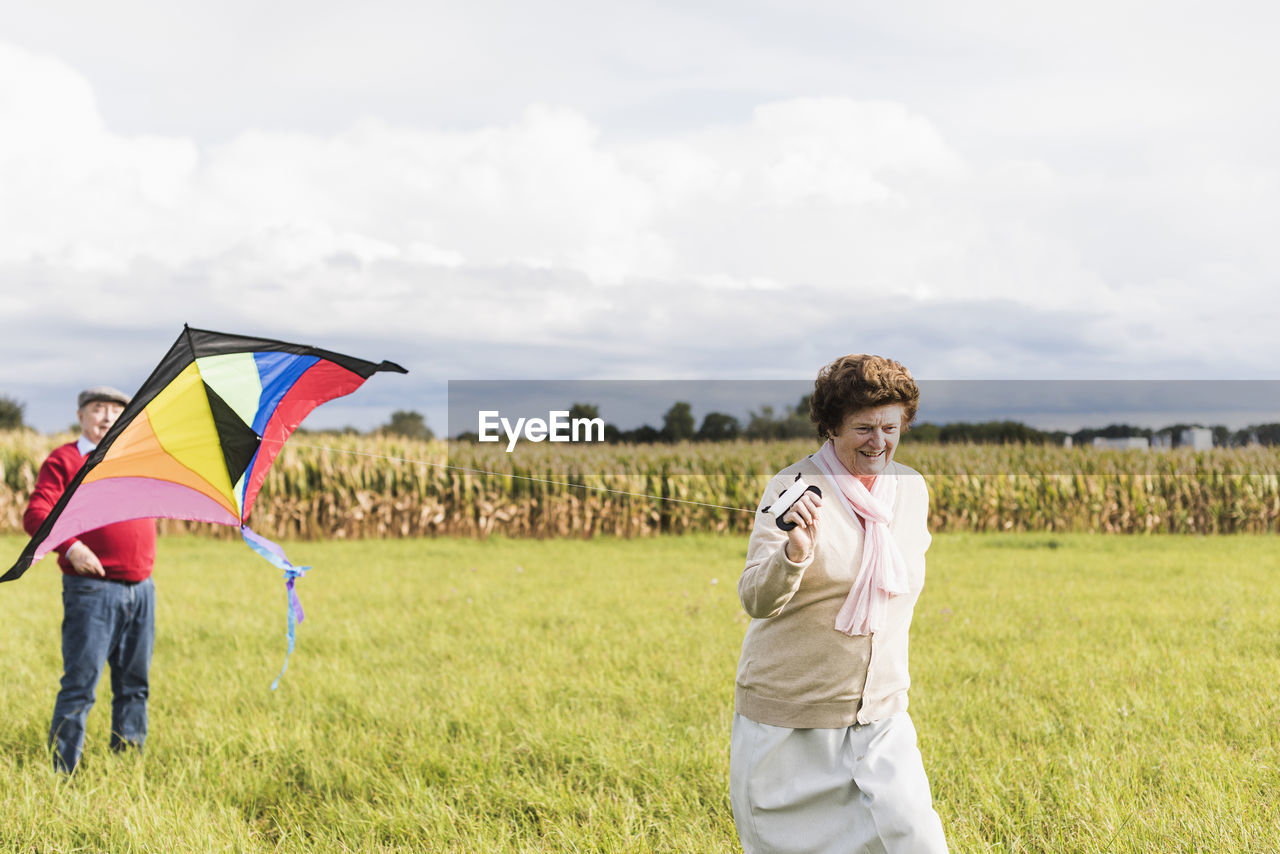 Senior couple flying kite in rural landscape