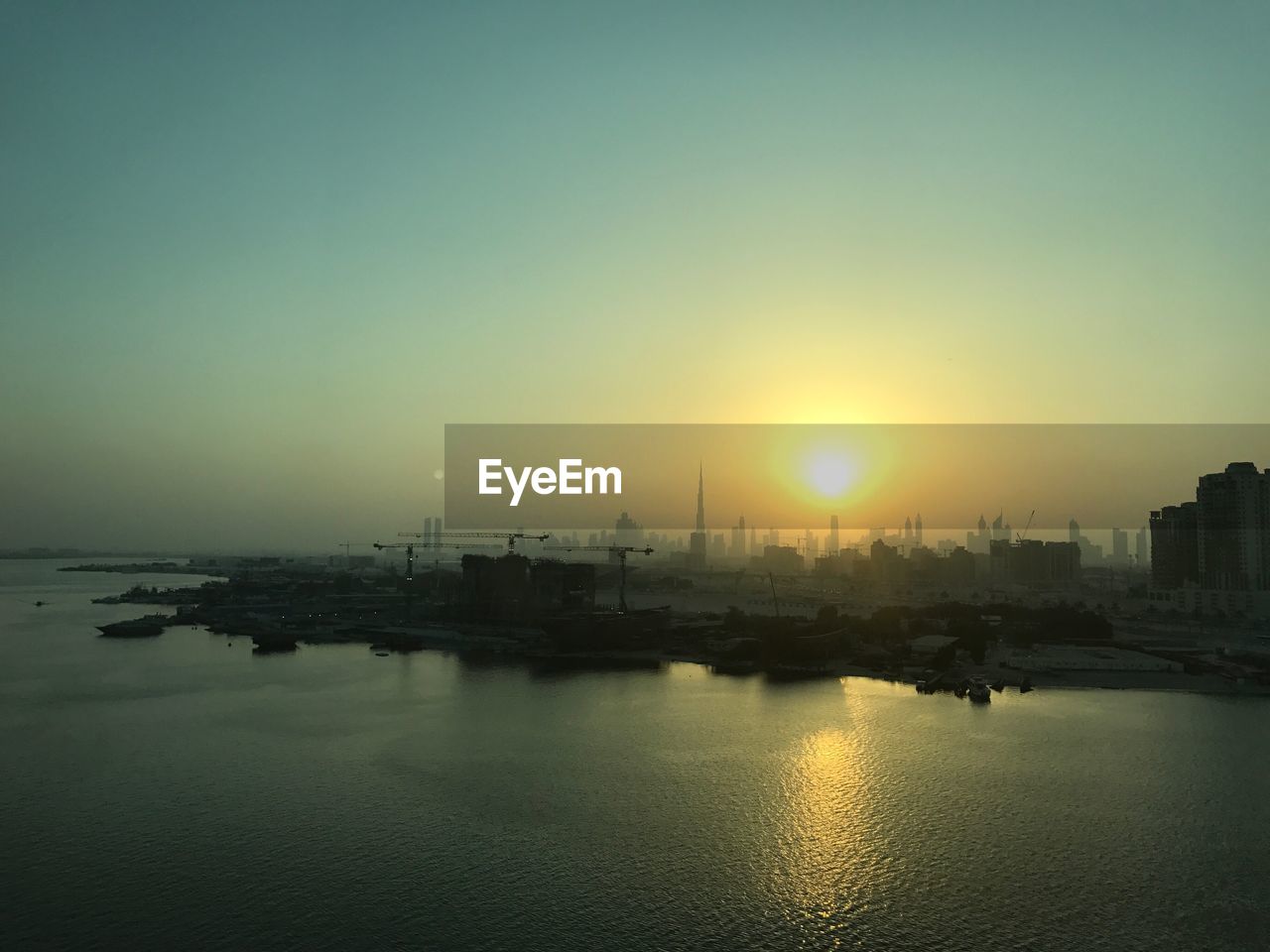 View of city at waterfront during sunset