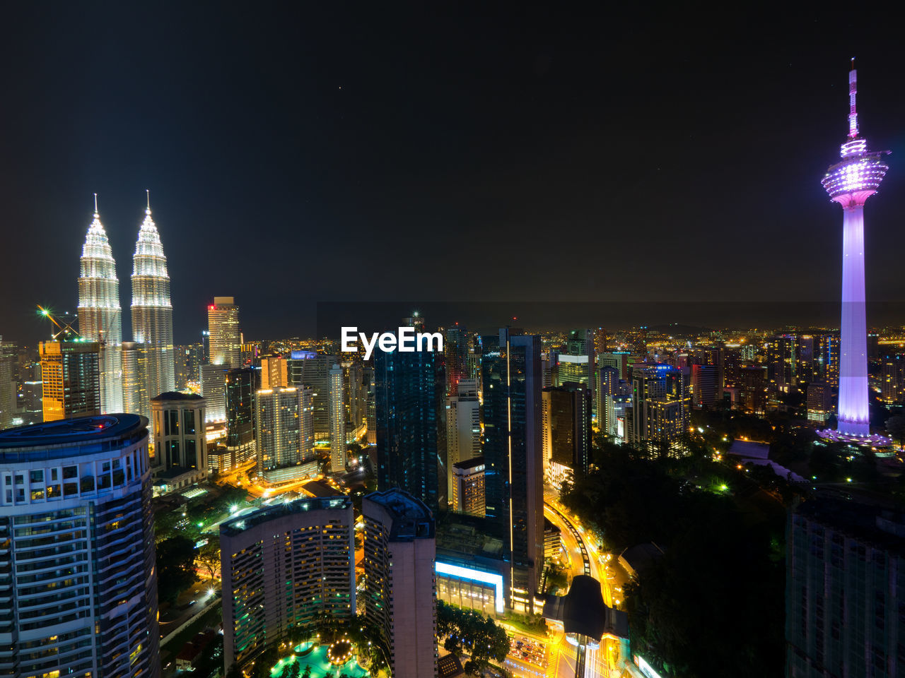 SKYSCRAPERS LIT UP AT NIGHT IN CITY