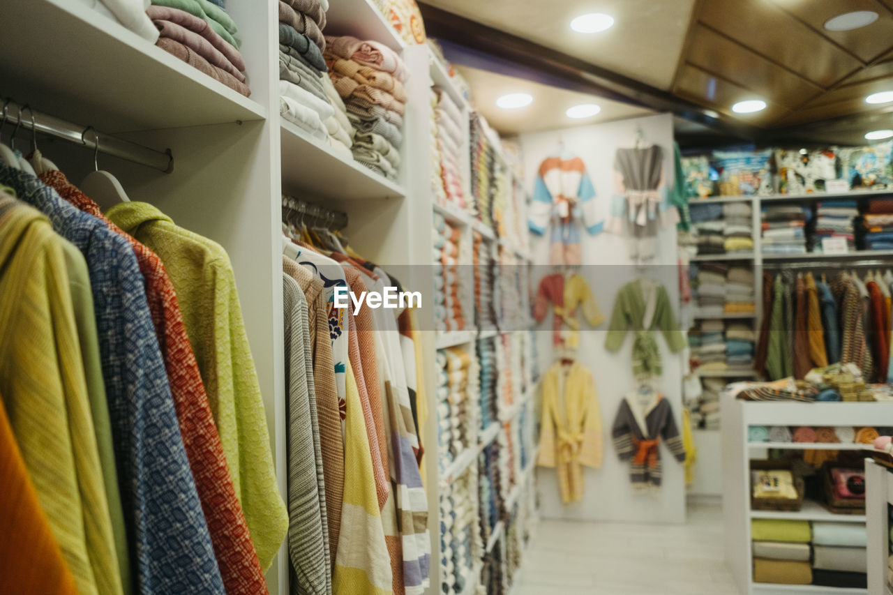 CLOTHES HANGING IN STORE FOR SALE IN MARKET