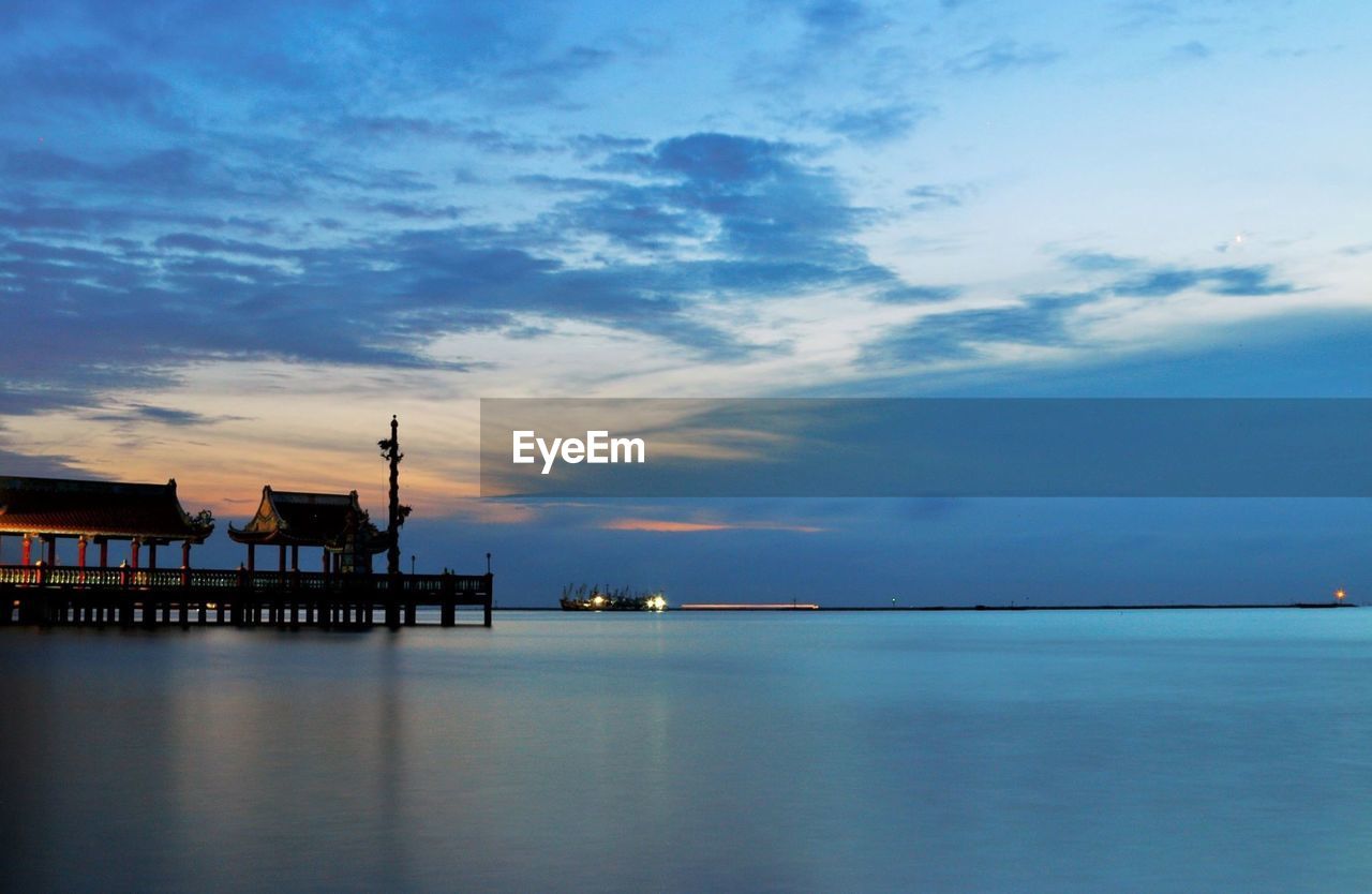 Pier over sea against cloudy sky