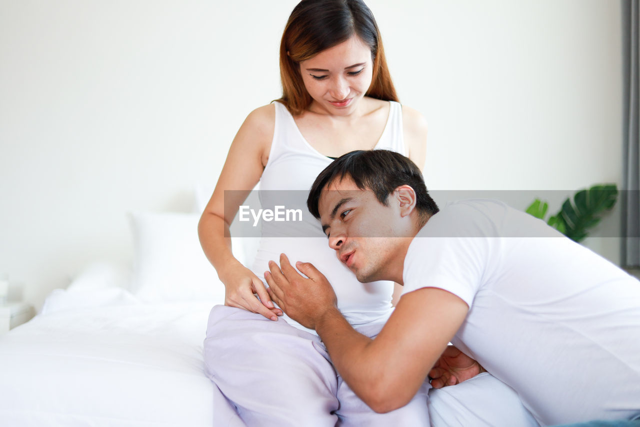 YOUNG COUPLE KISSING IN BED